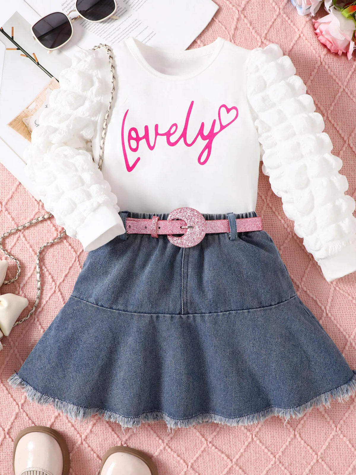 Outfit laid flat with a pink belt