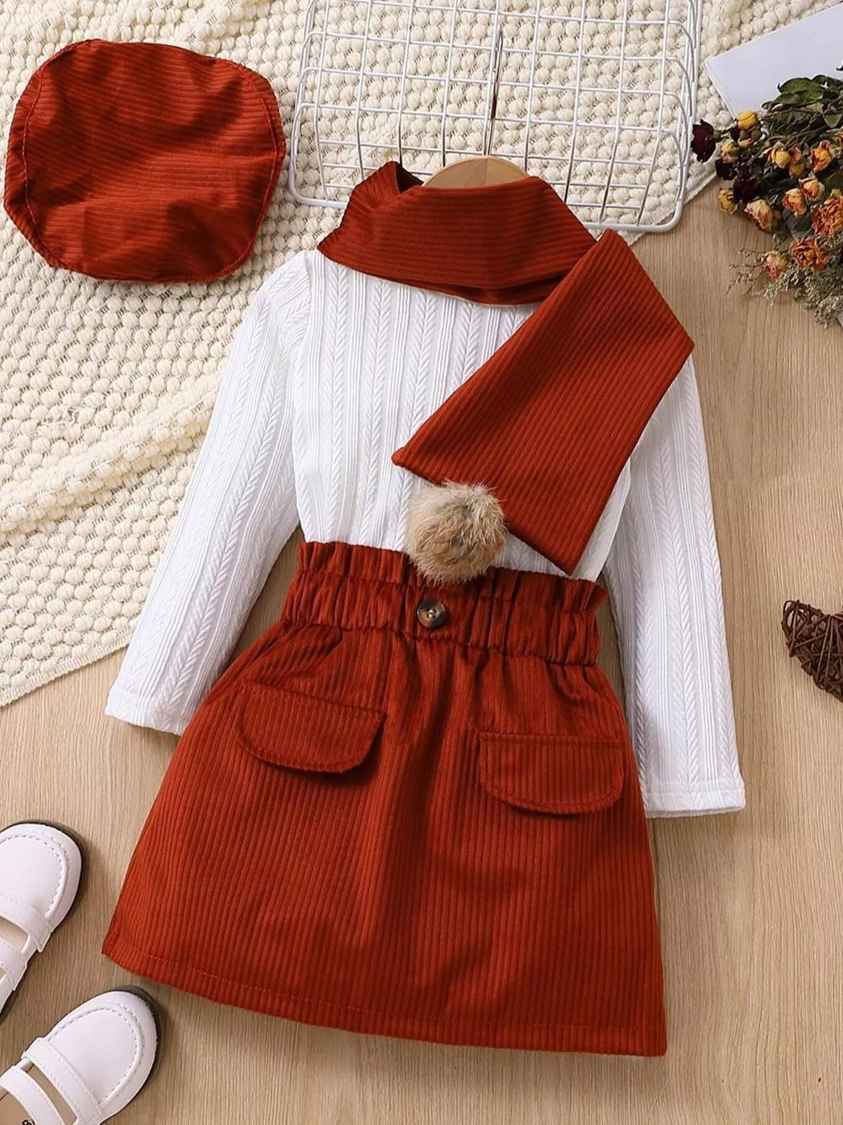 White top with rust skirt, scarf and beret laid flat