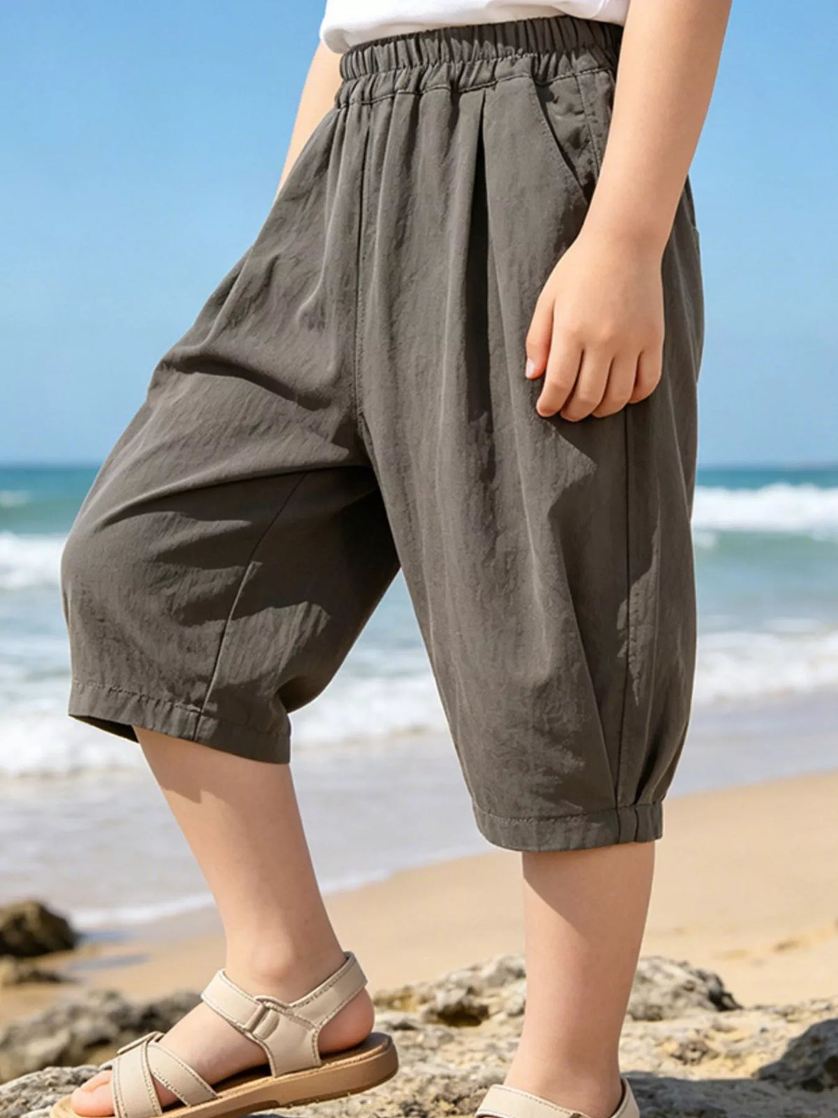 Dark gray loose-fit capri pants on a child
