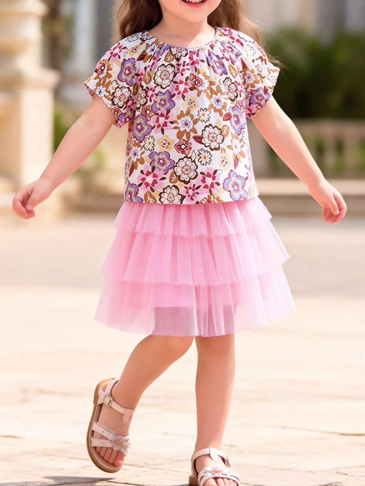 Multicolored floral top with a pink tiered tulle skirt on a child