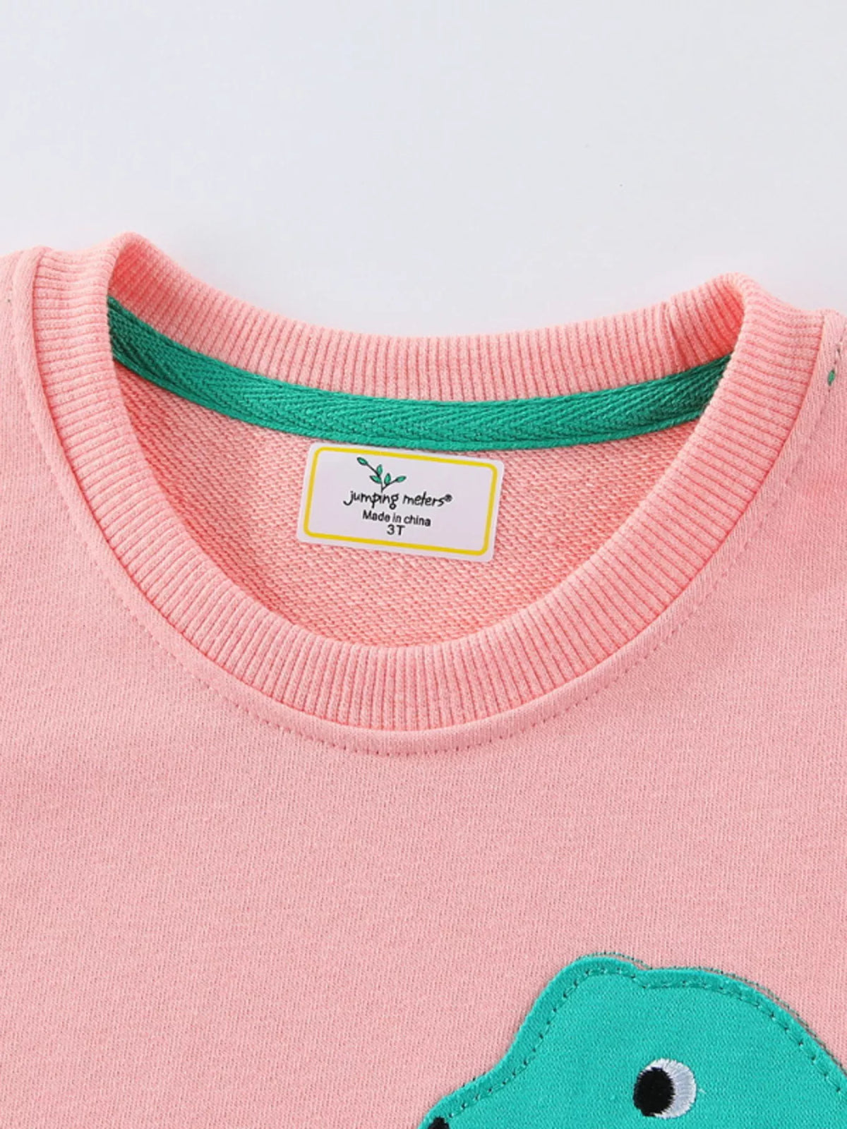 Pink dinosaur applique long sleeve top with blue spikes — round neckline