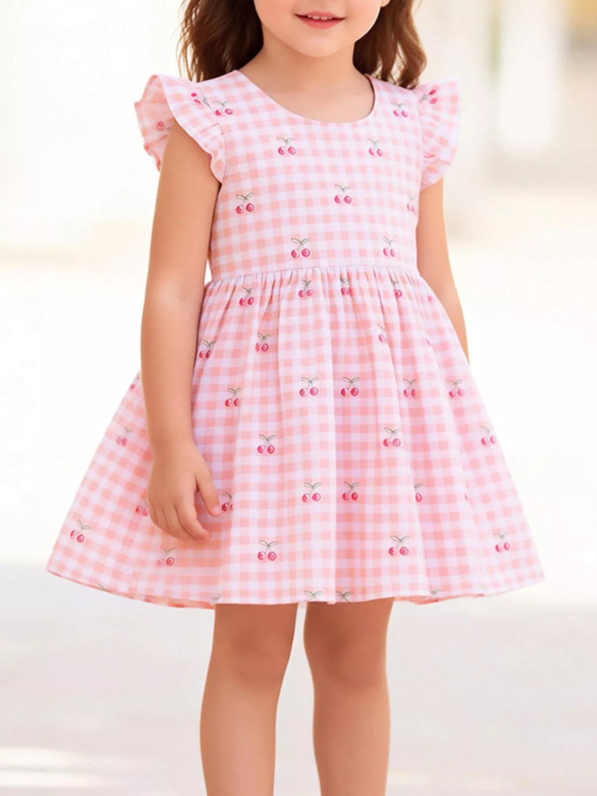 Pink cherry gingham dress with ruffled sleeves on a child