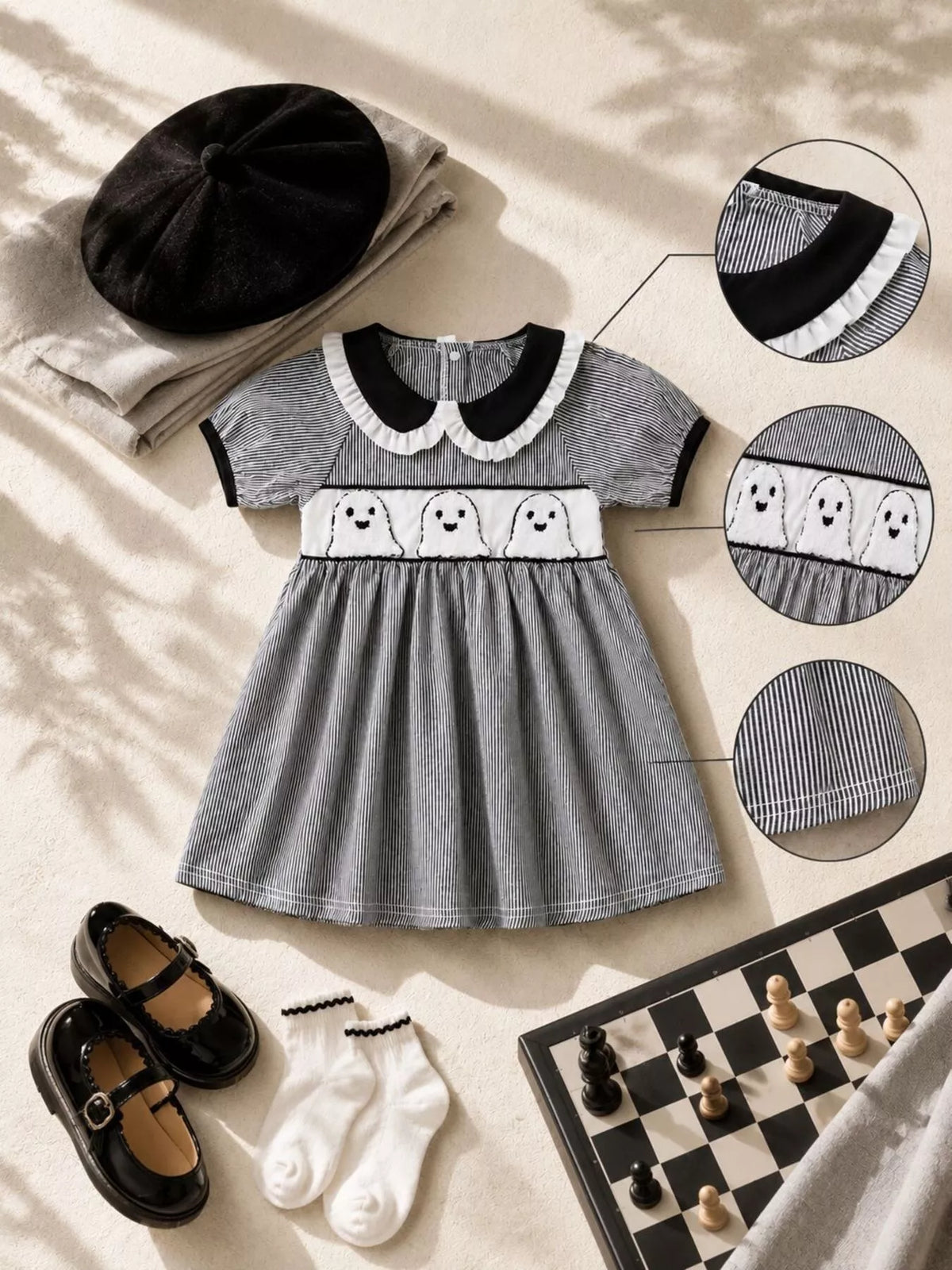 Black gingham dress laid flat with collar, embroidery and fabric detail insets