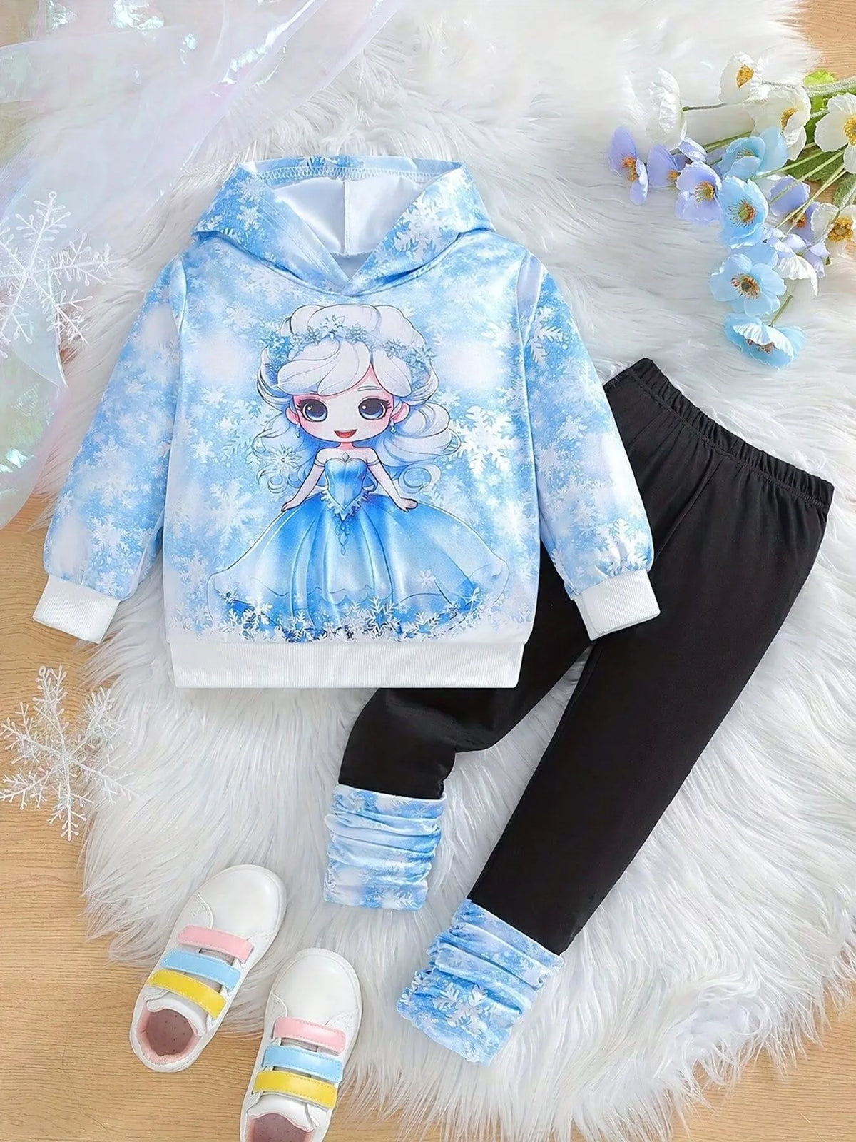 Blue snowflake hoodie with black leggings and blue cuffs laid flat