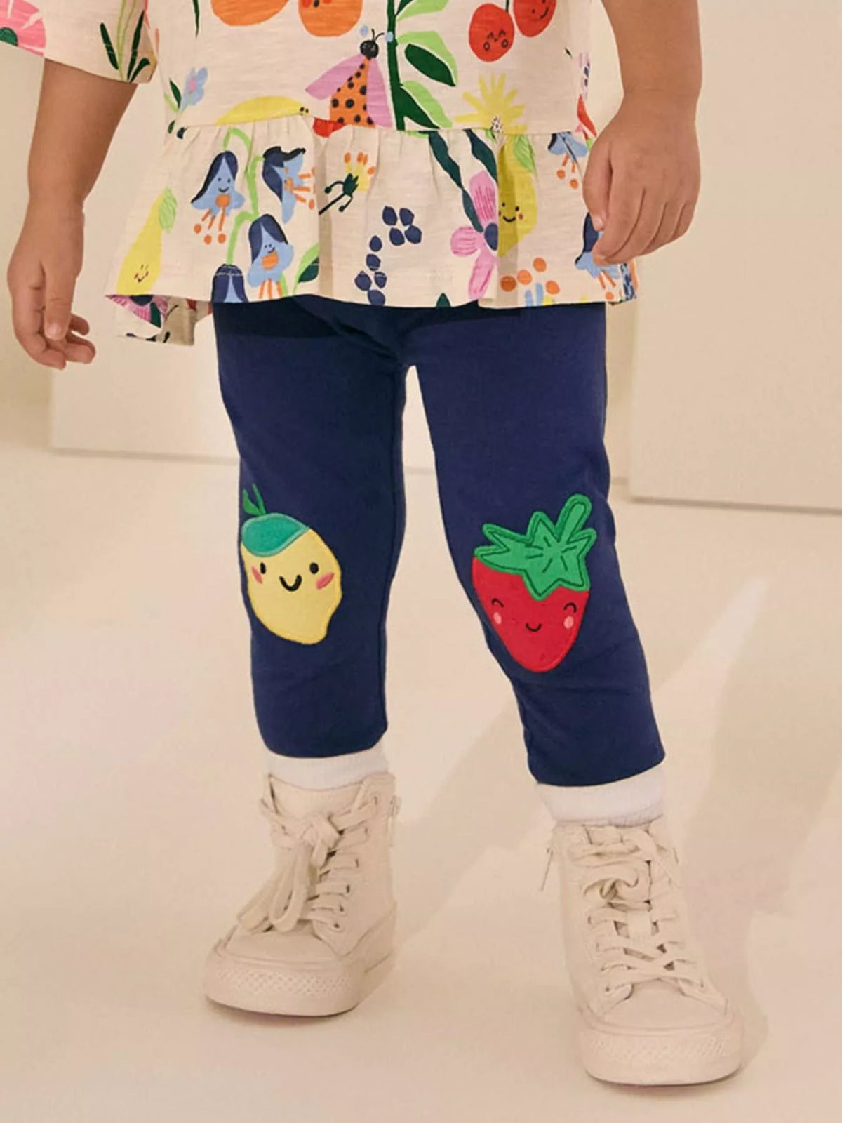 Navy fruit-applique leggings on a child