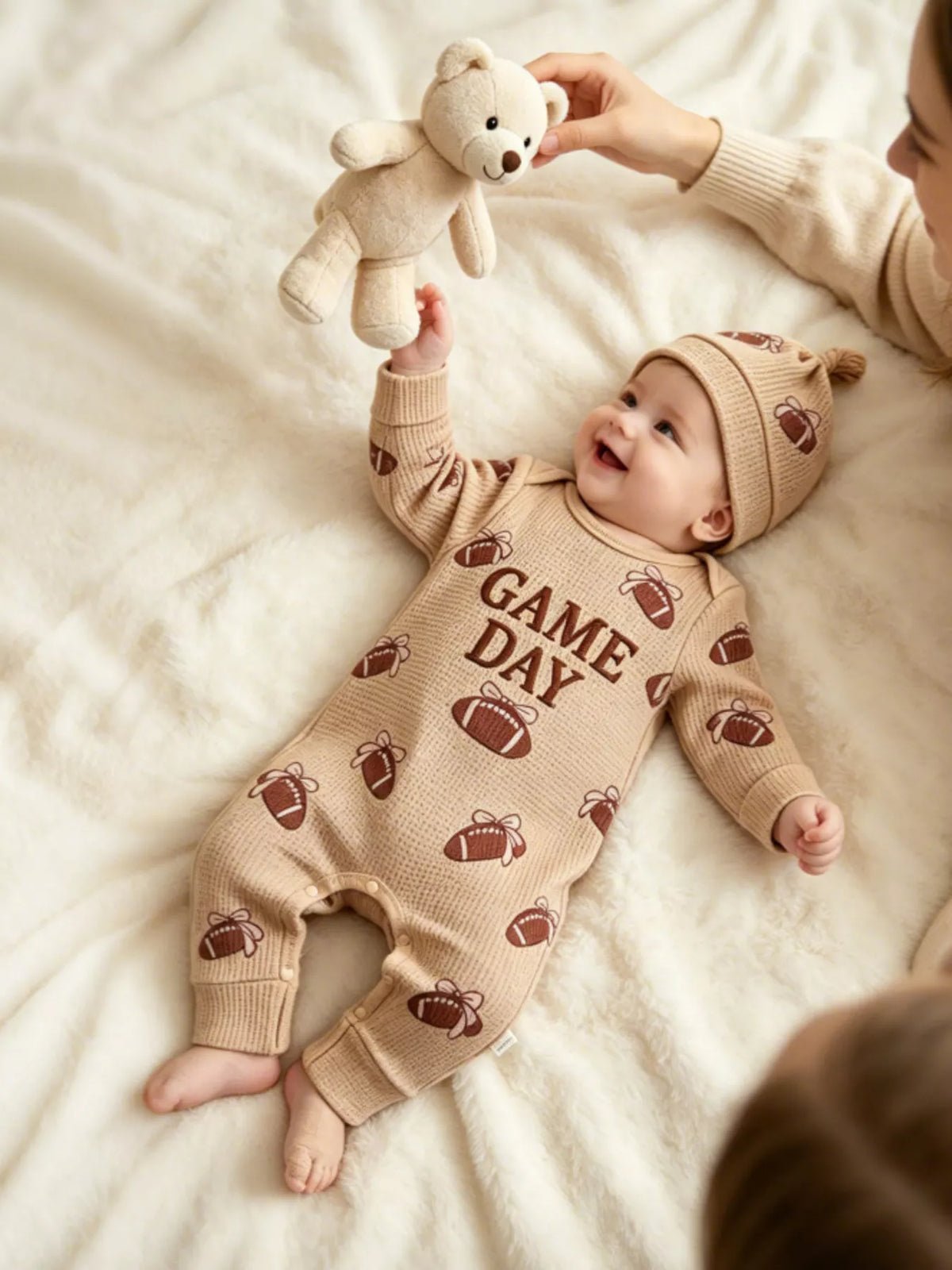 Baby in the football outfit looking toward an adult