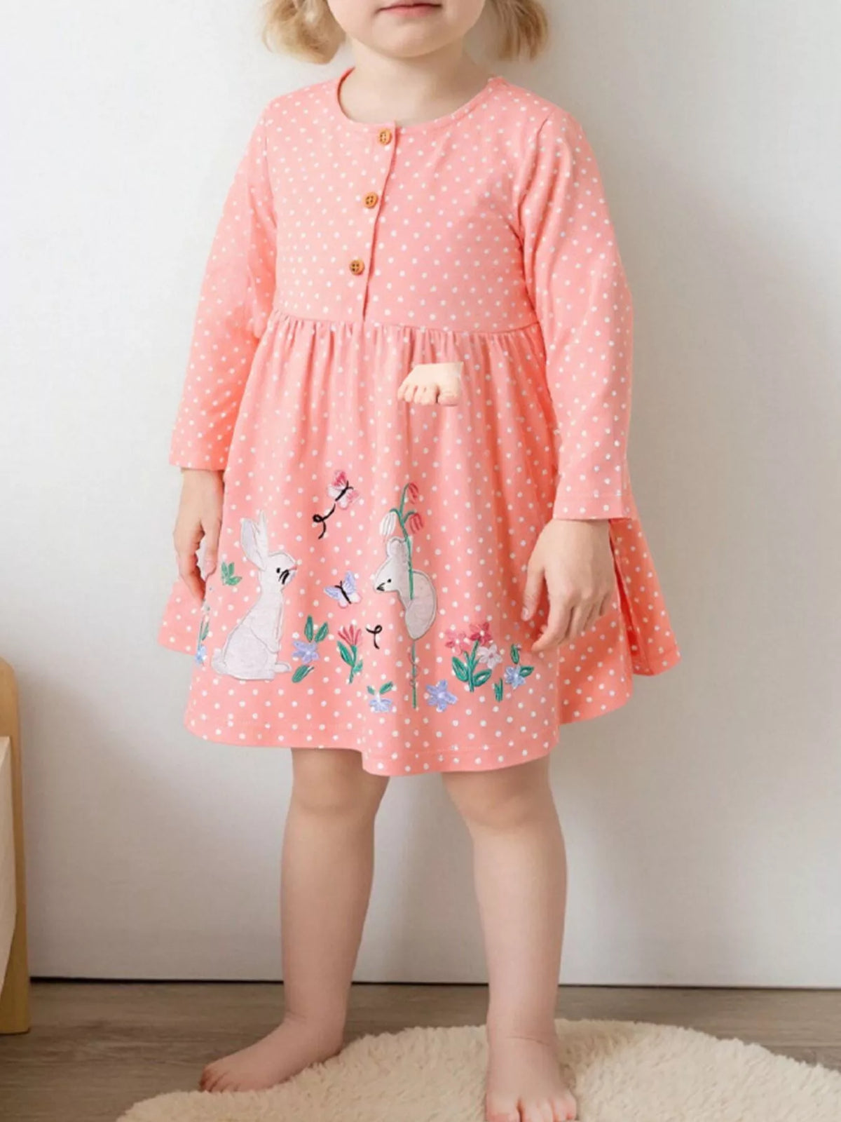 Pink polka-dot long-sleeve dress with bunny motifs on a child