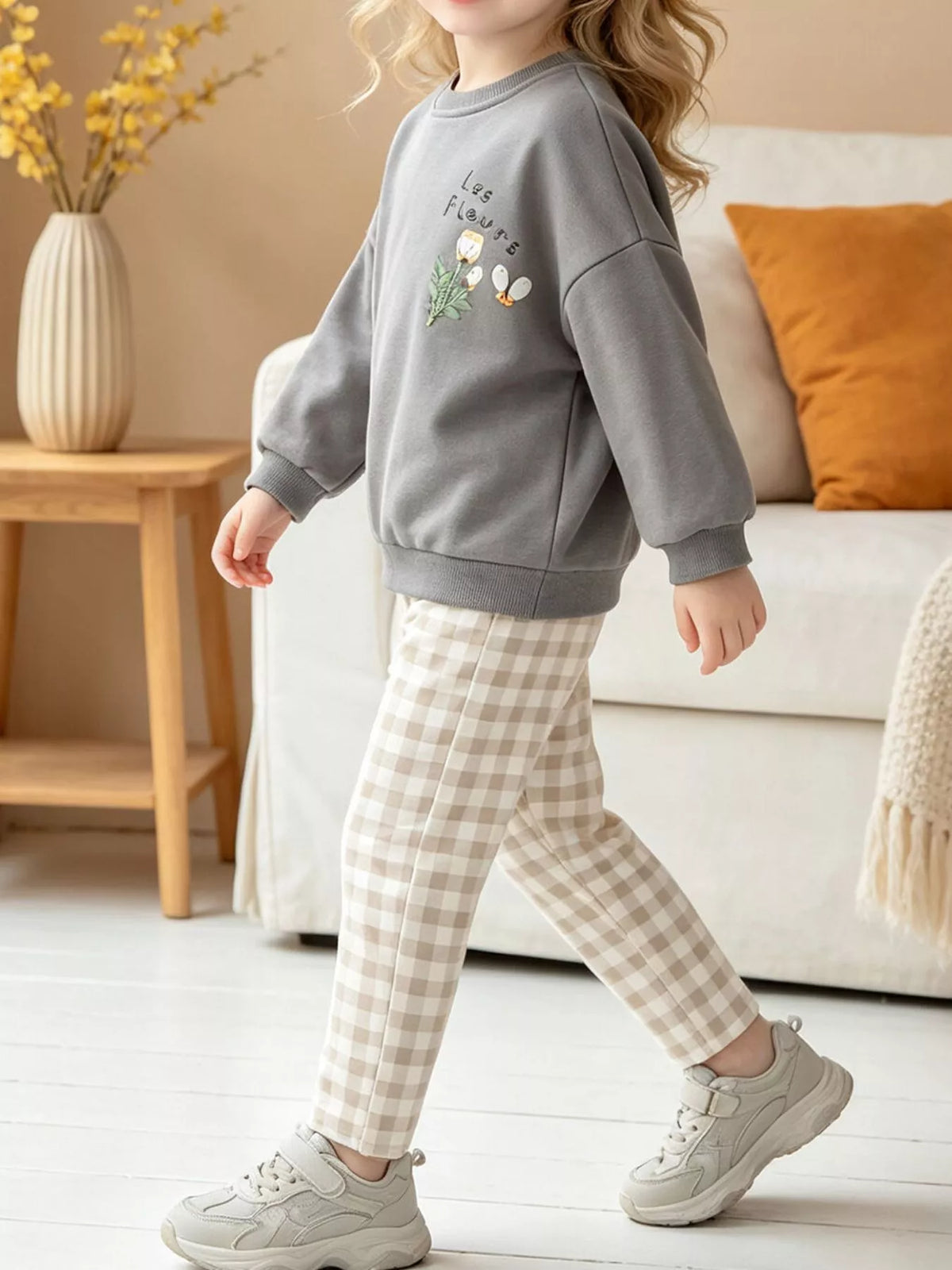 Gray floral sweatshirt with beige checked pants on a child