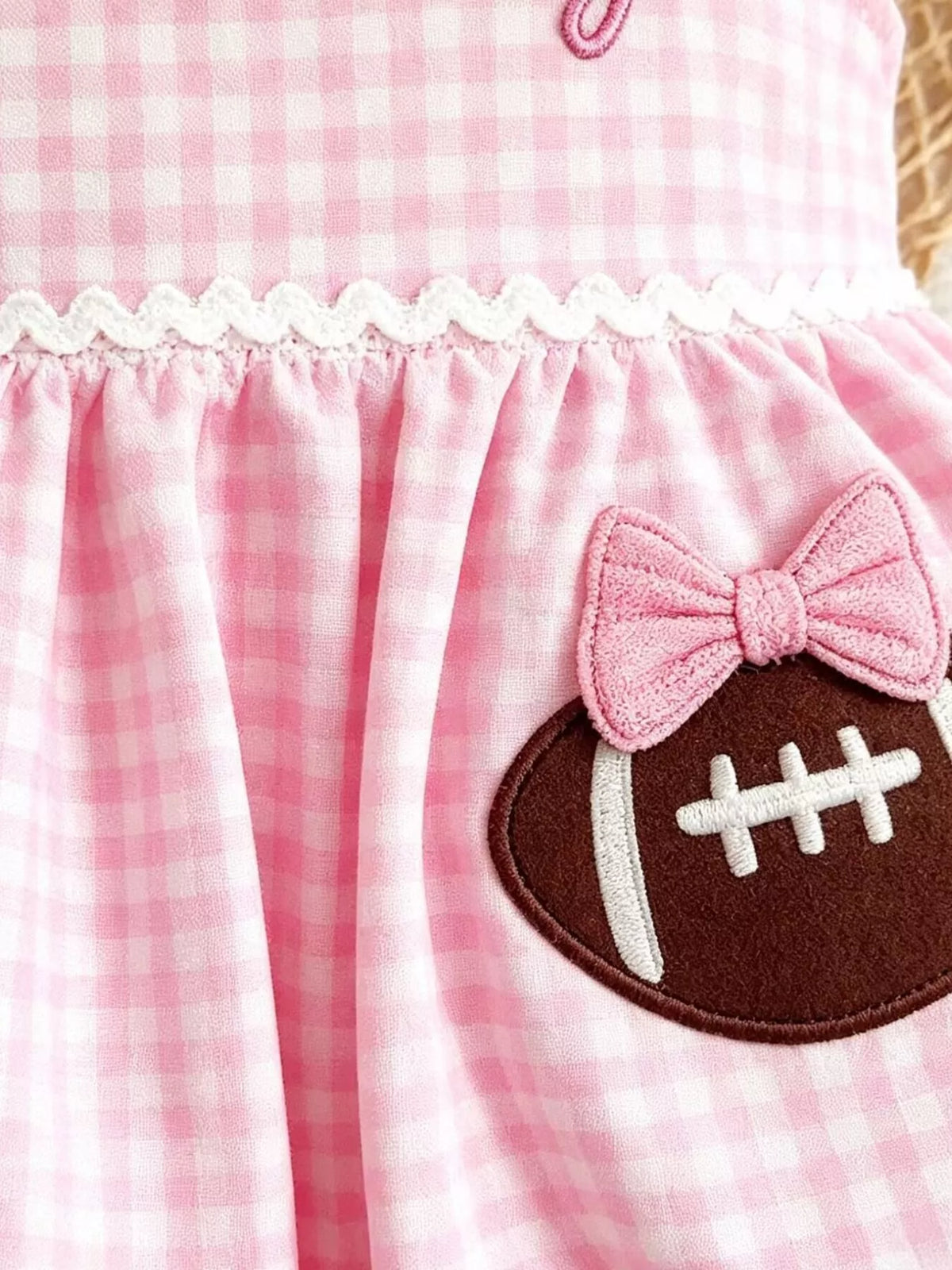 Football applique with pink bow and white waist trim