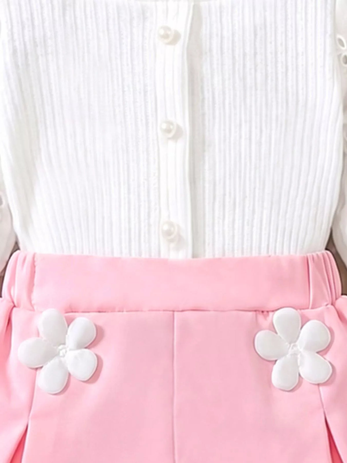 White button placket above pink shorts waistband