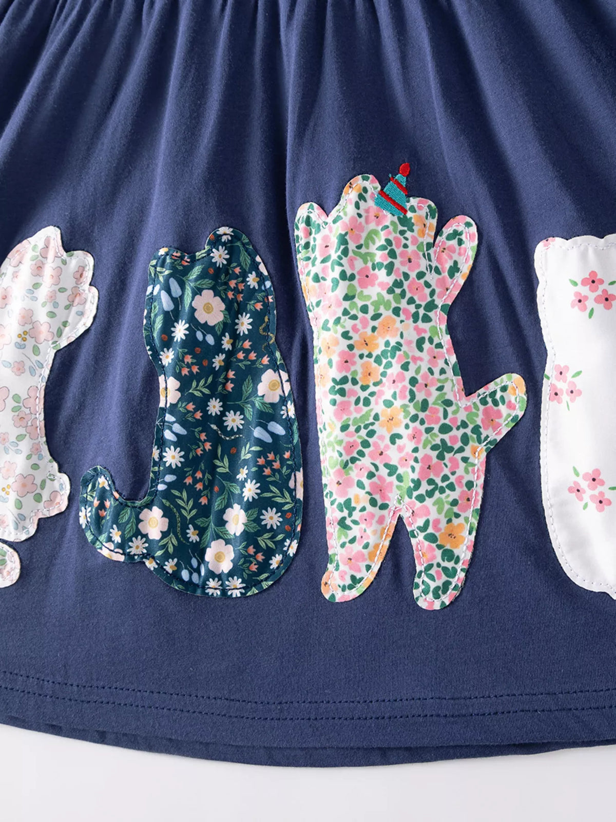 Floral-pattern cat appliques along the skirt