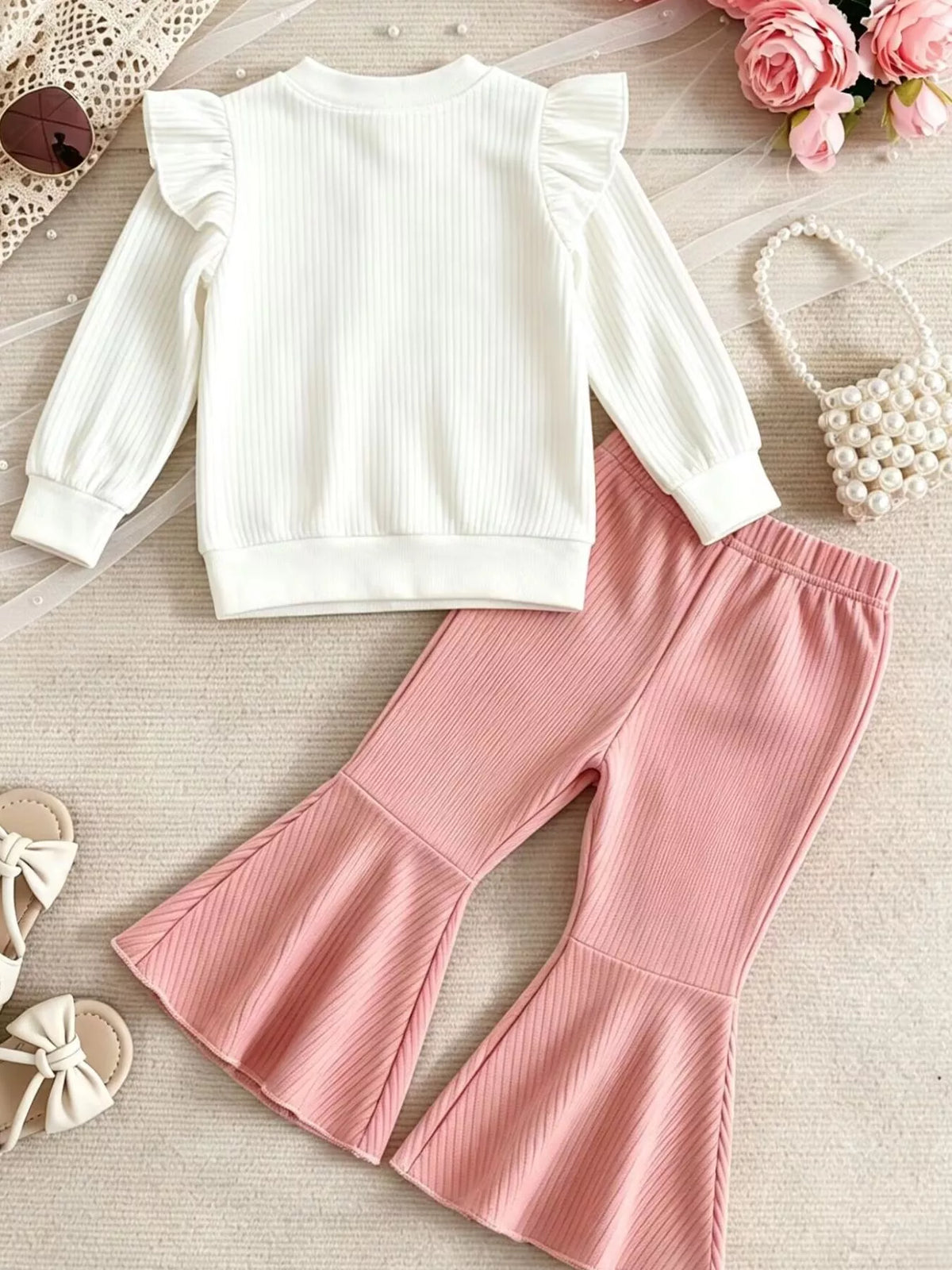 Back of the white top and pink flared pants
