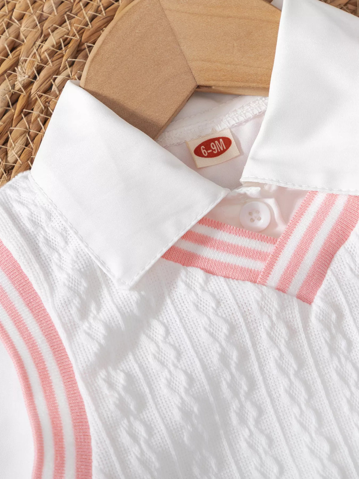 White pointed collar above pink-striped knit neckline