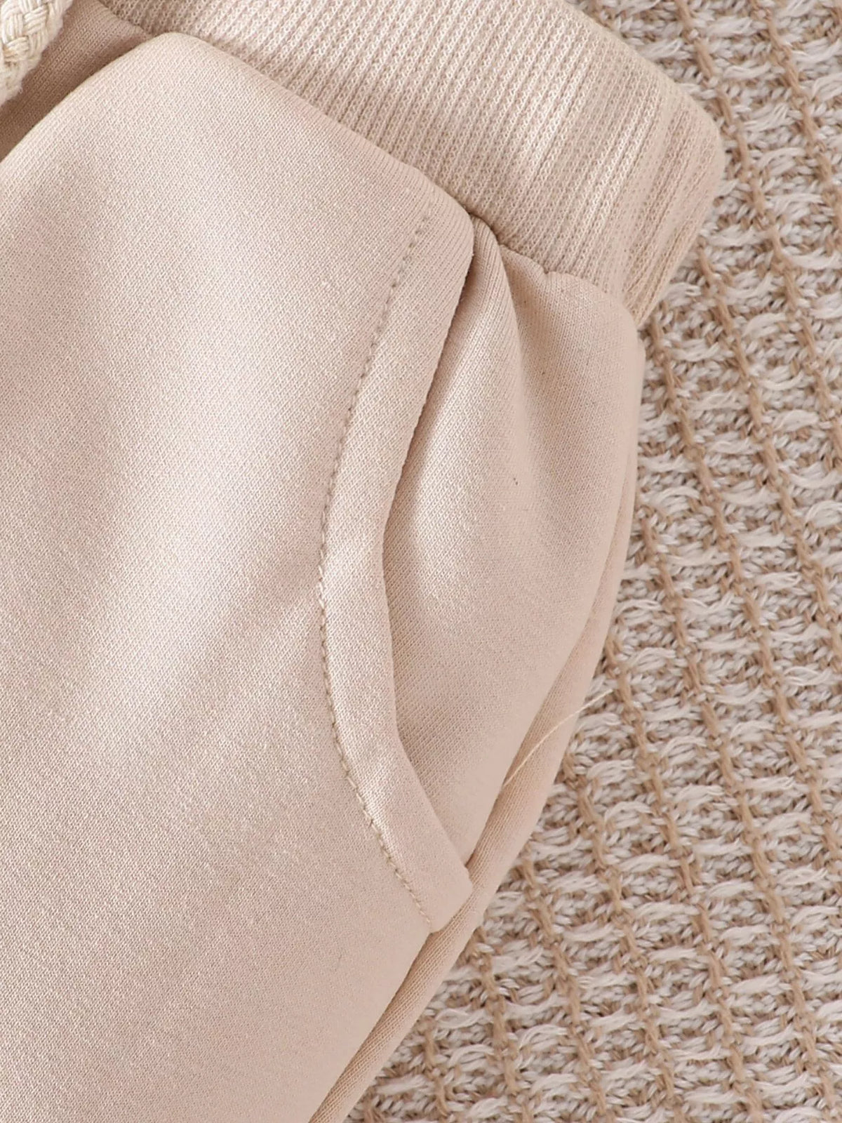 Curved pocket below the cream elastic waistband