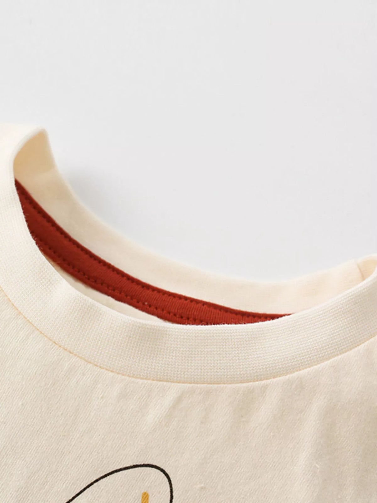 Cream safari animal graphic shirt — round neckline with rust inner tape