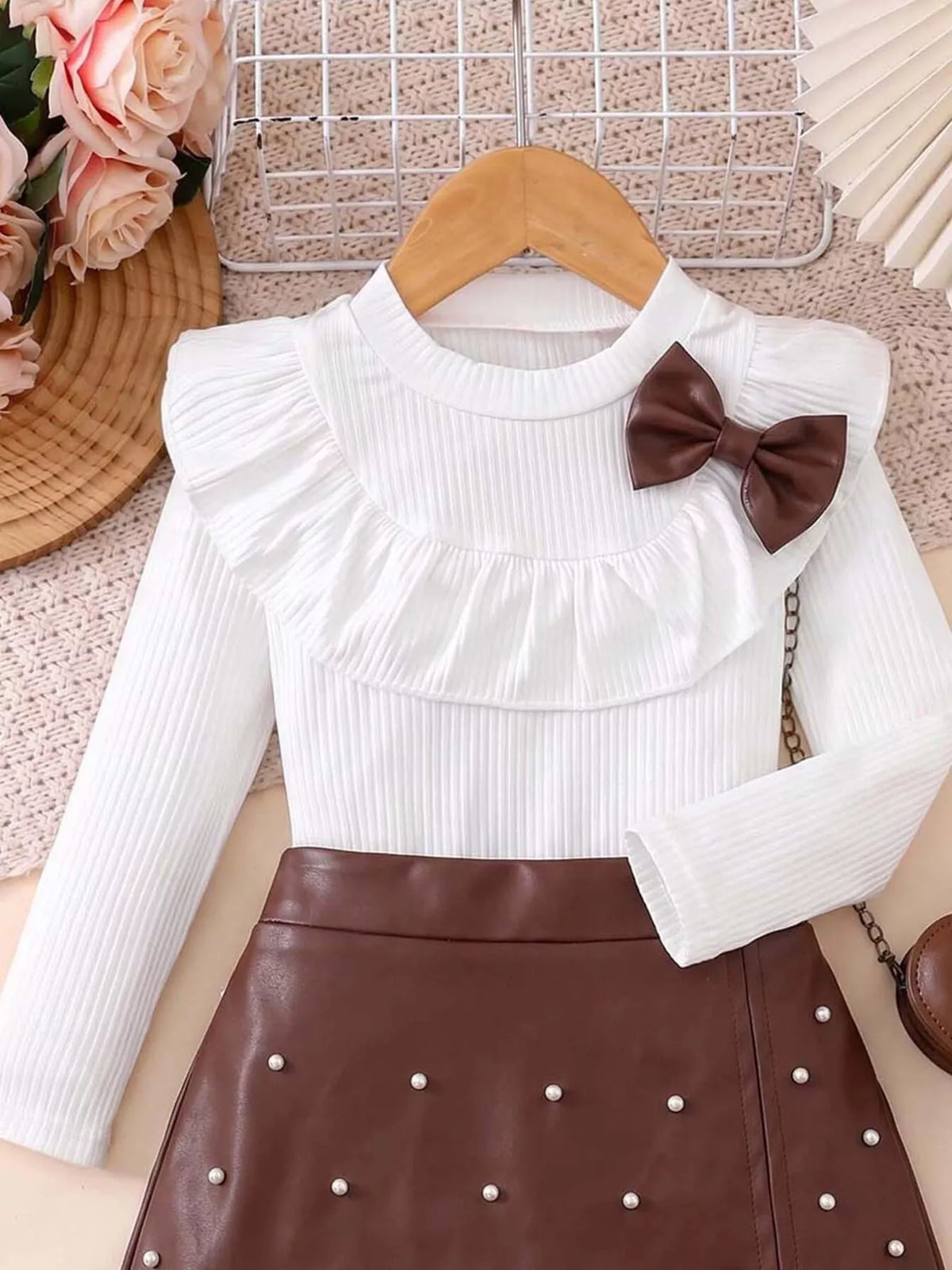 White ruffled bib with a brown bow