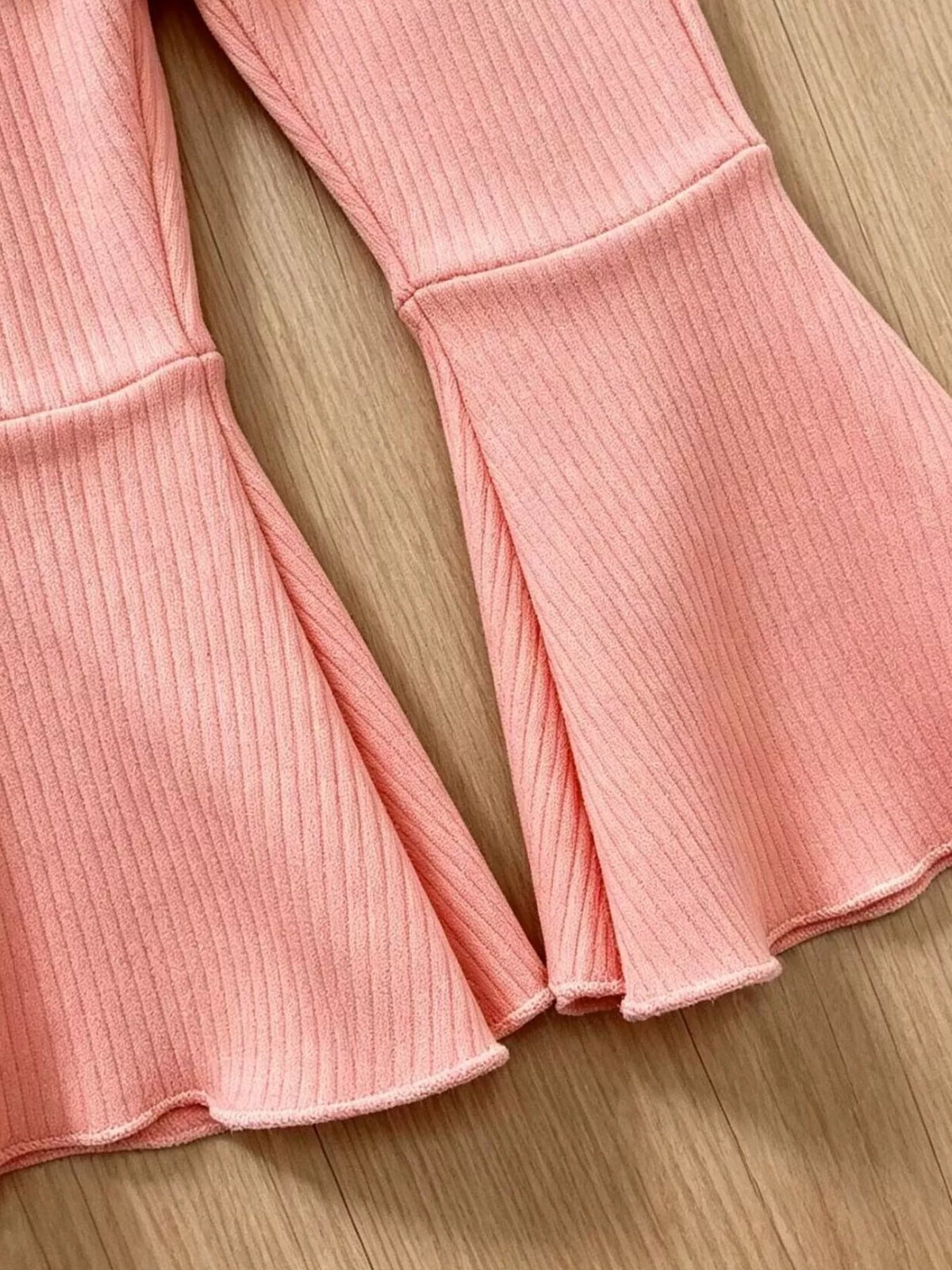 Flared hems on pink ribbed pants