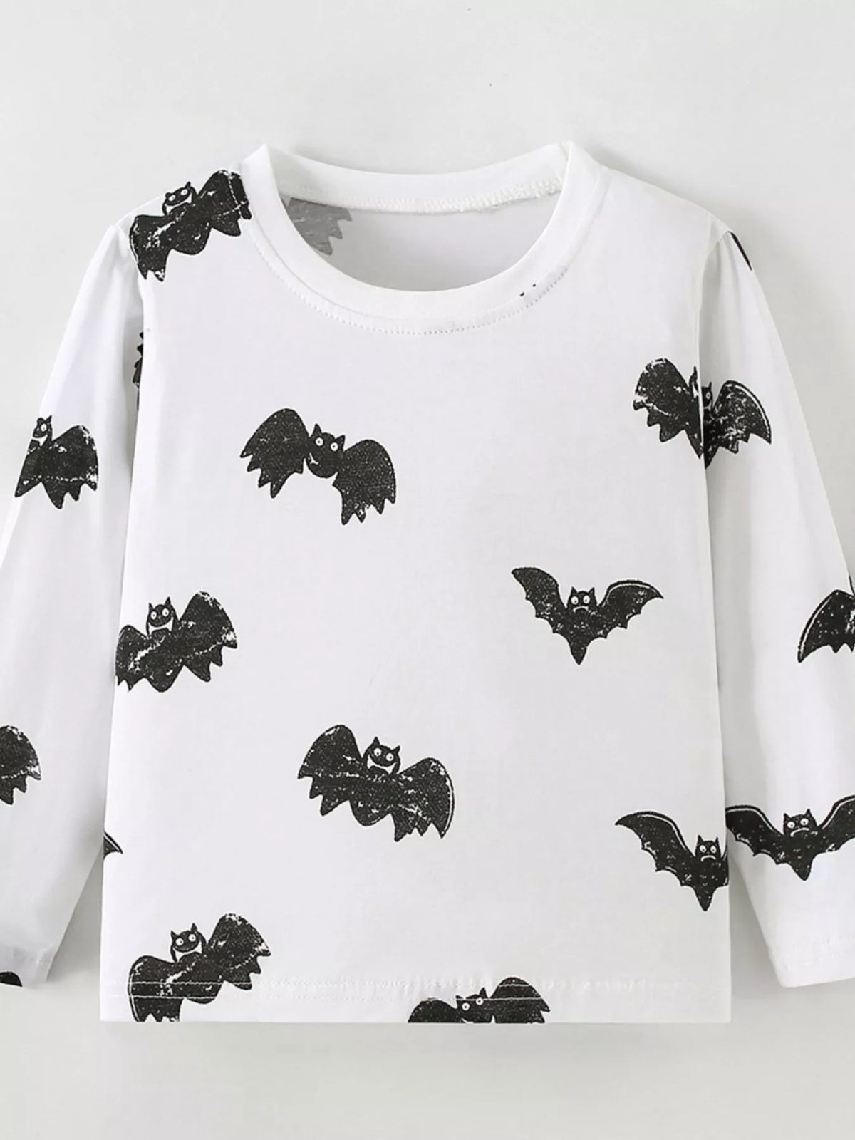 White long-sleeve tee with black bat print laid flat