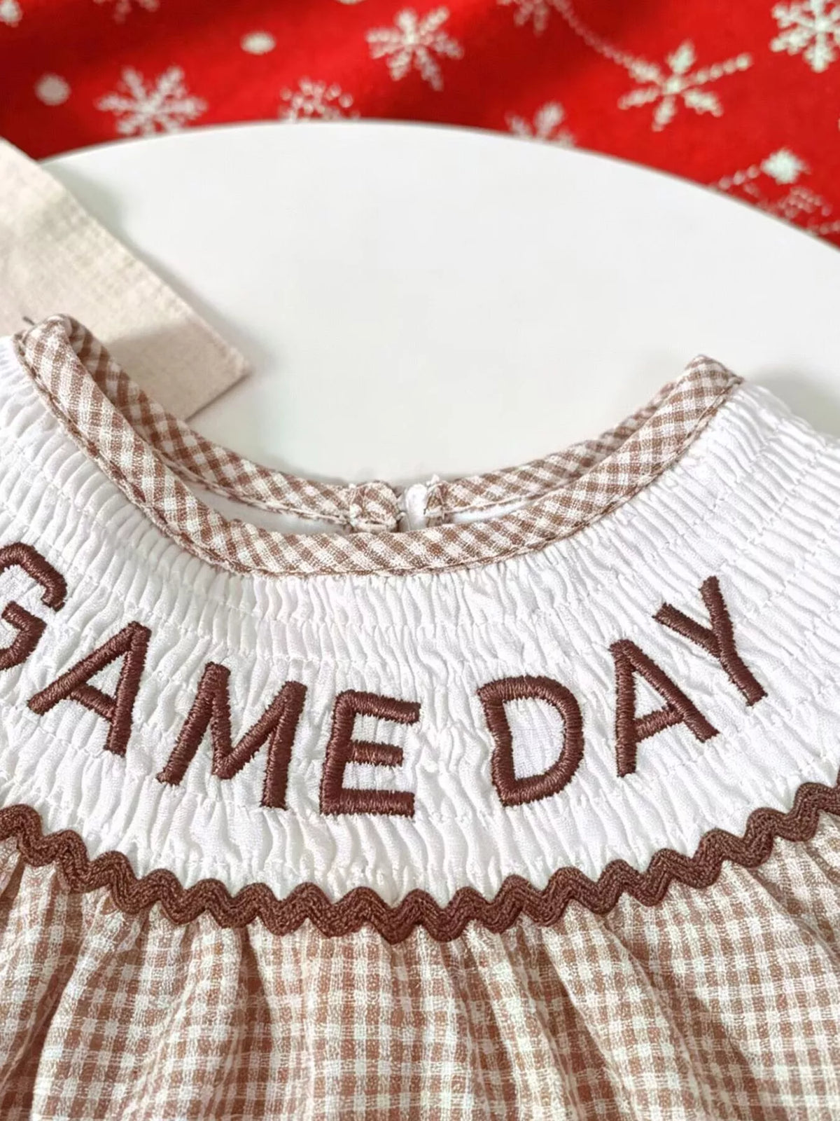 Game Day embroidery across the white smocked yoke
