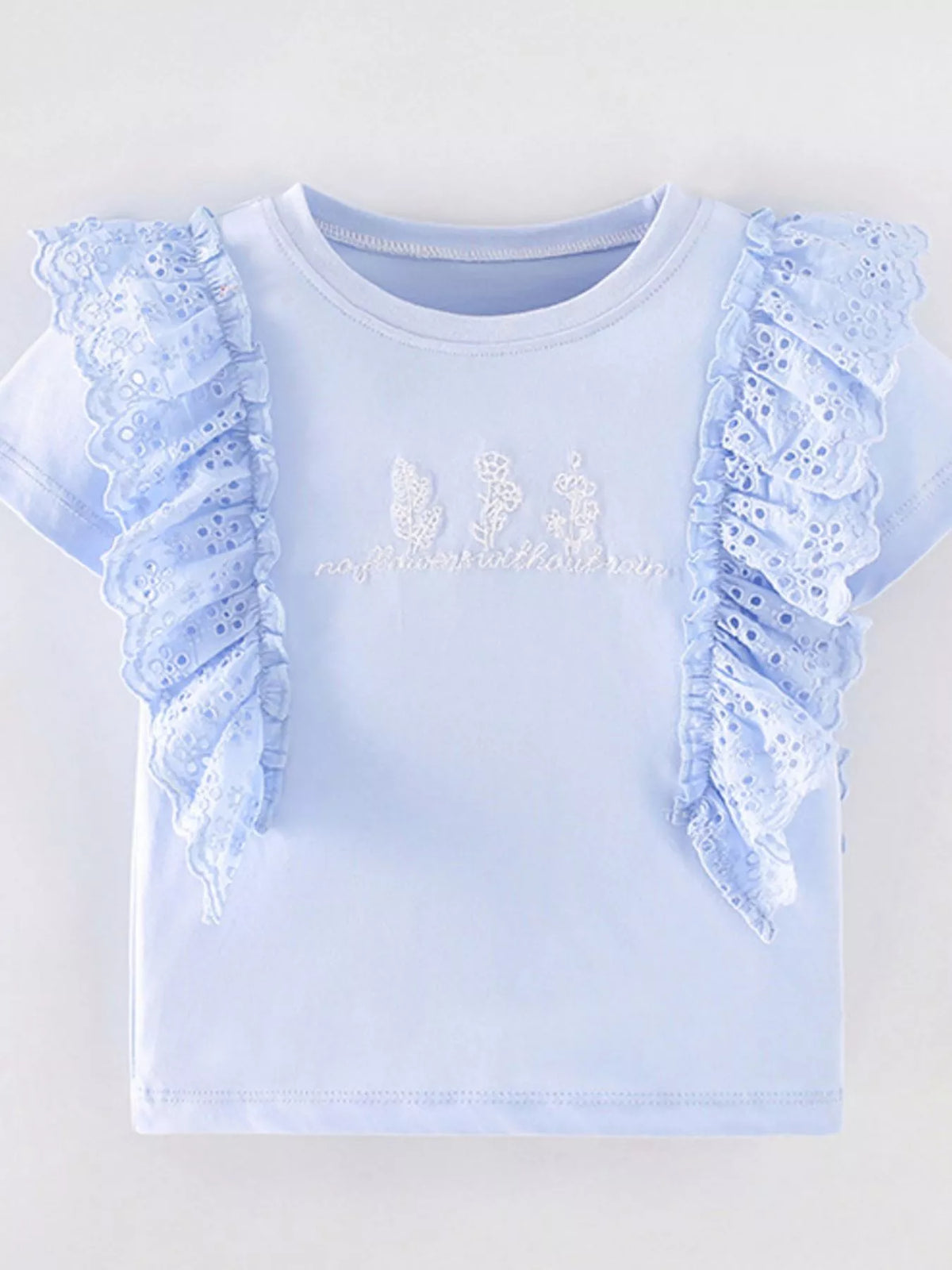 Light blue tee with eyelet shoulder ruffles laid flat
