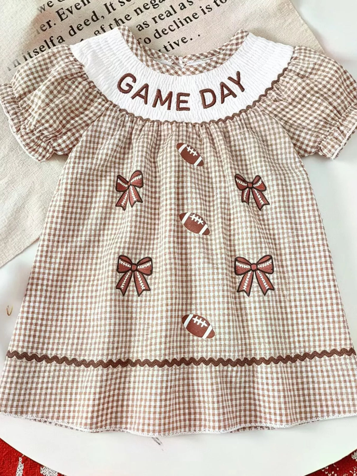 Brown gingham Game Day puff-sleeve dress laid flat