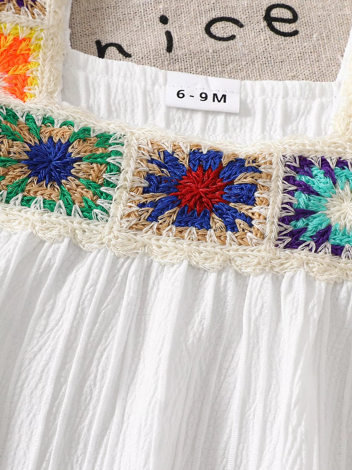 Crochet flower band above the gathered white bodice