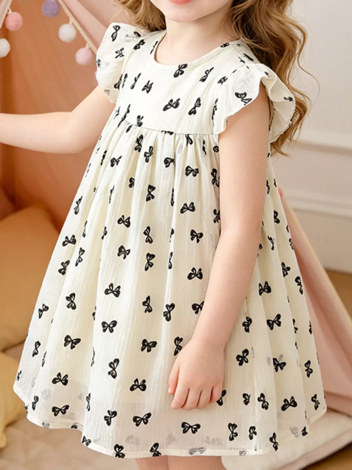 Cream bow-print flutter-sleeve dress on a child