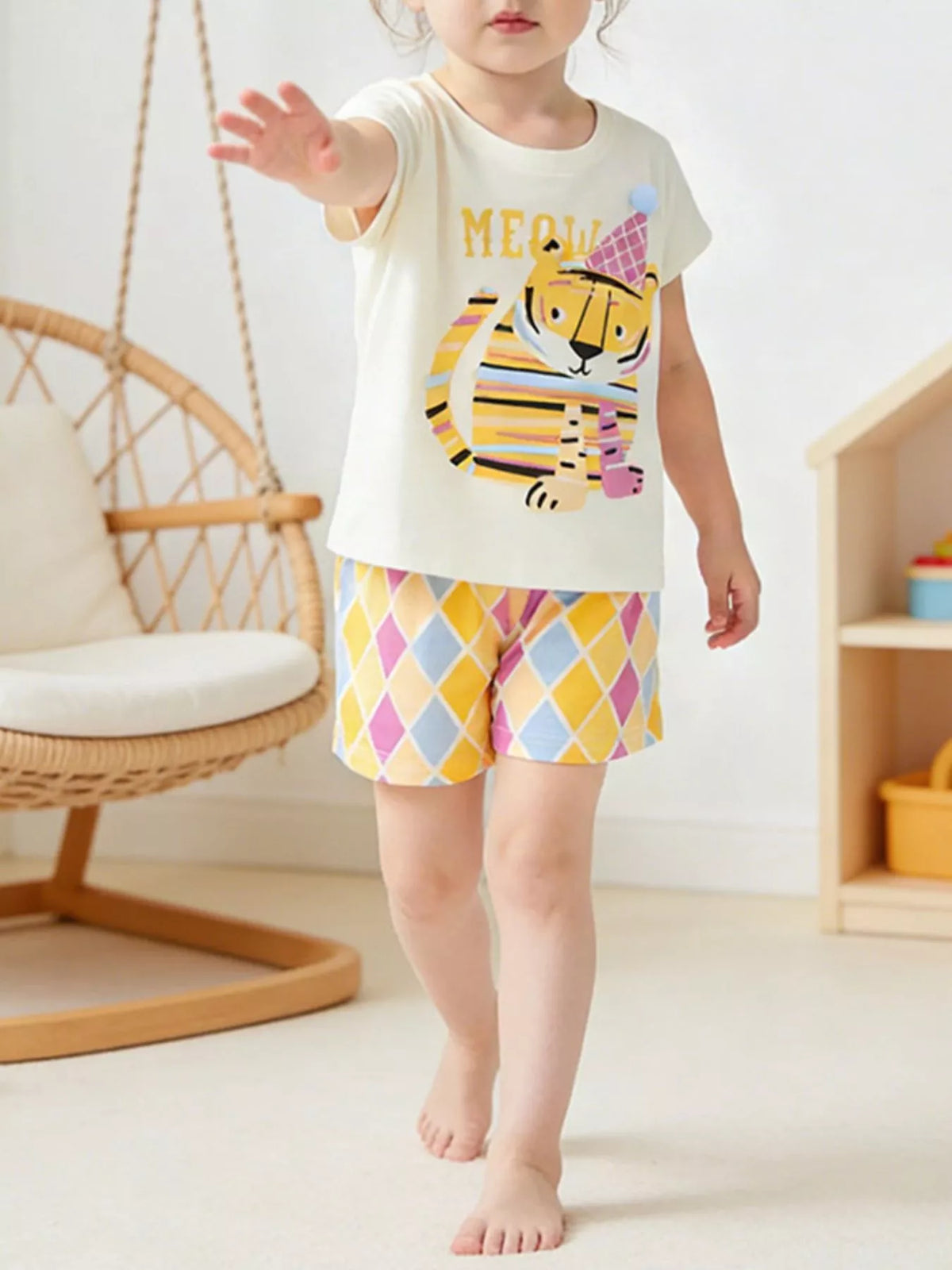 Cream tiger-graphic tee with pastel diamond-print shorts on a child