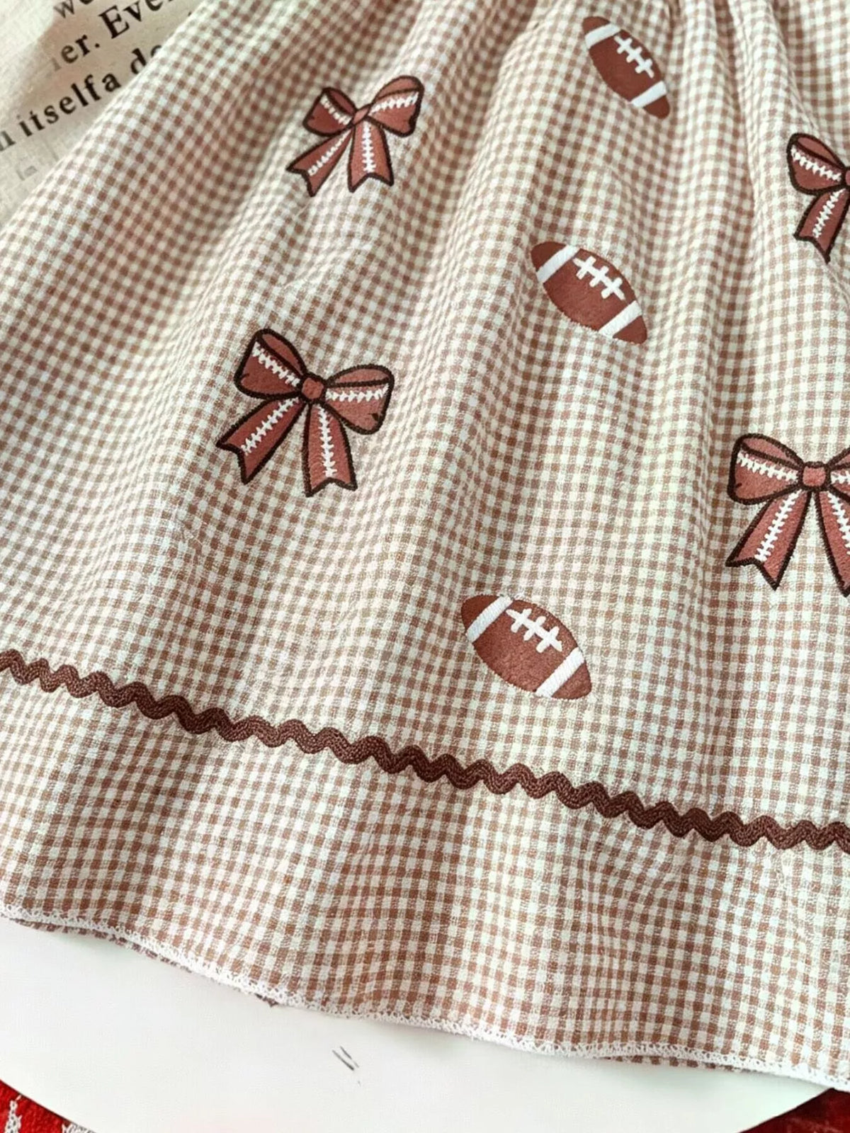Football and bow motifs above the skirt hem