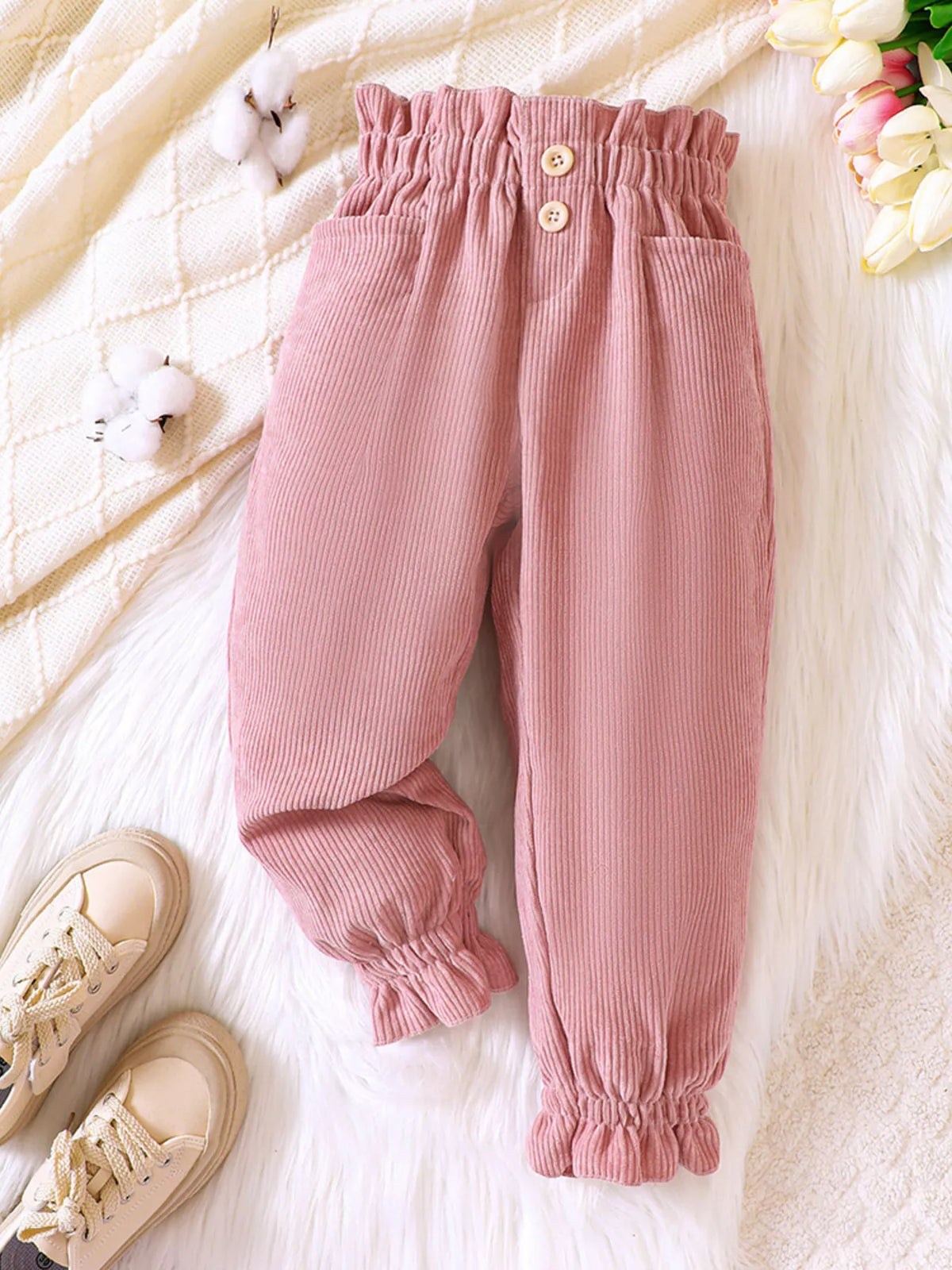 Pink corduroy pants laid flat