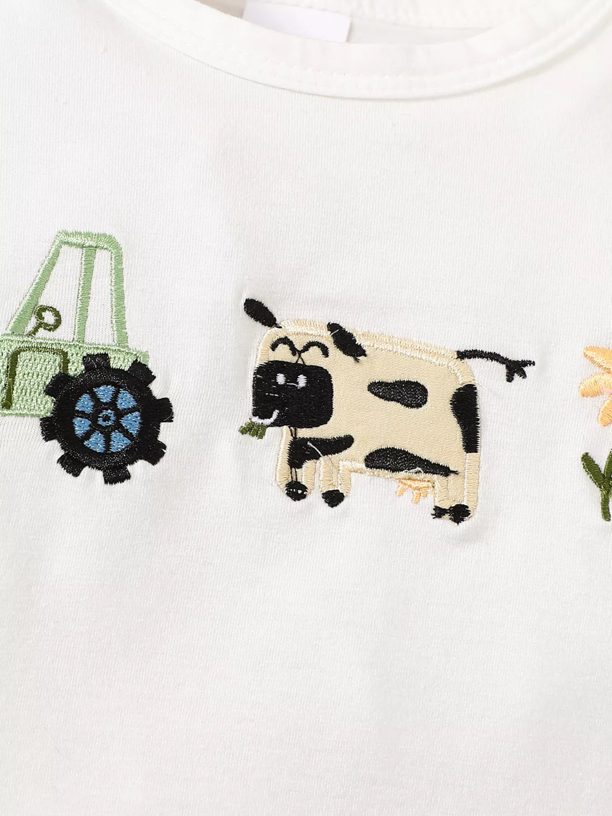 Tractor, cow and sunflower motifs on white fabric