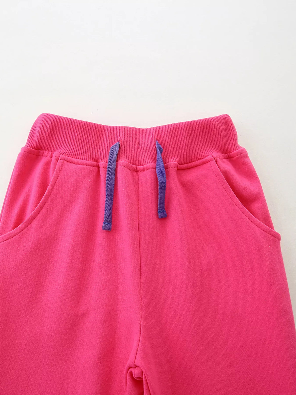 Purple drawstring and front pockets on pink joggers