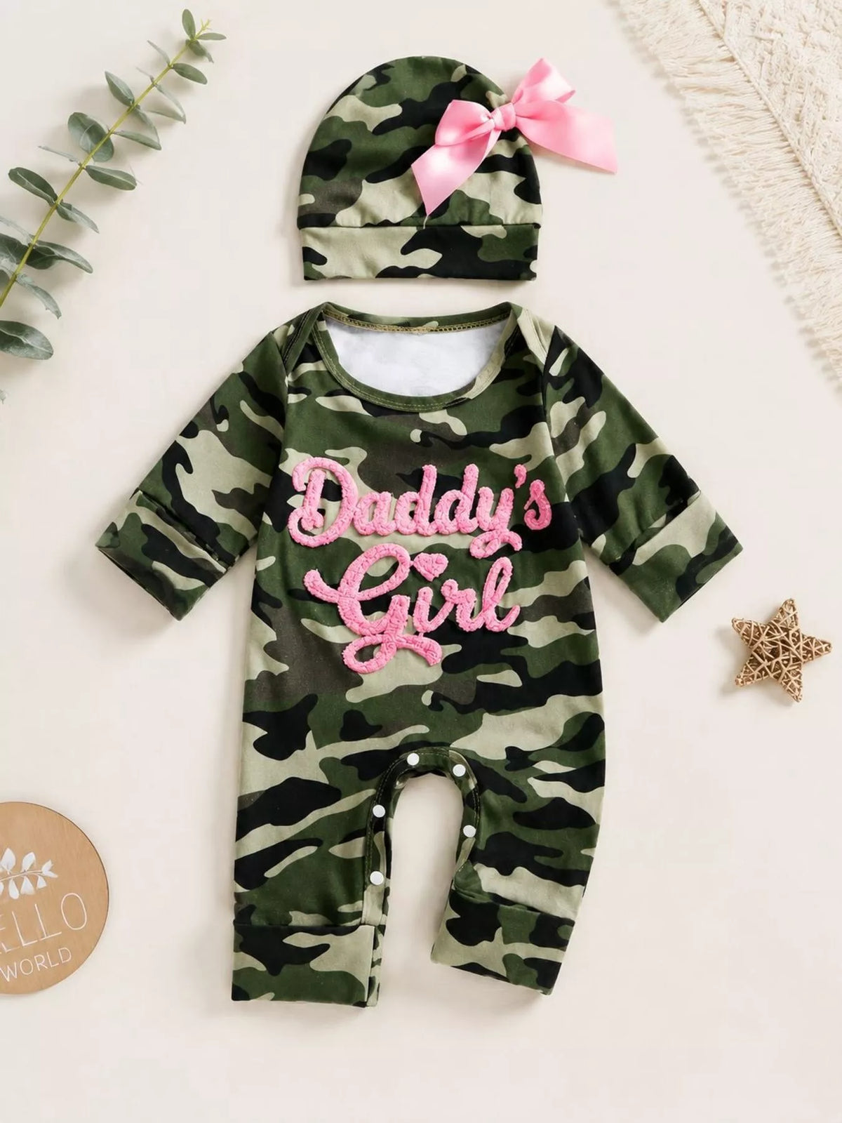 Green camouflage Daddy's Girl jumpsuit with a pink-bow hat laid flat