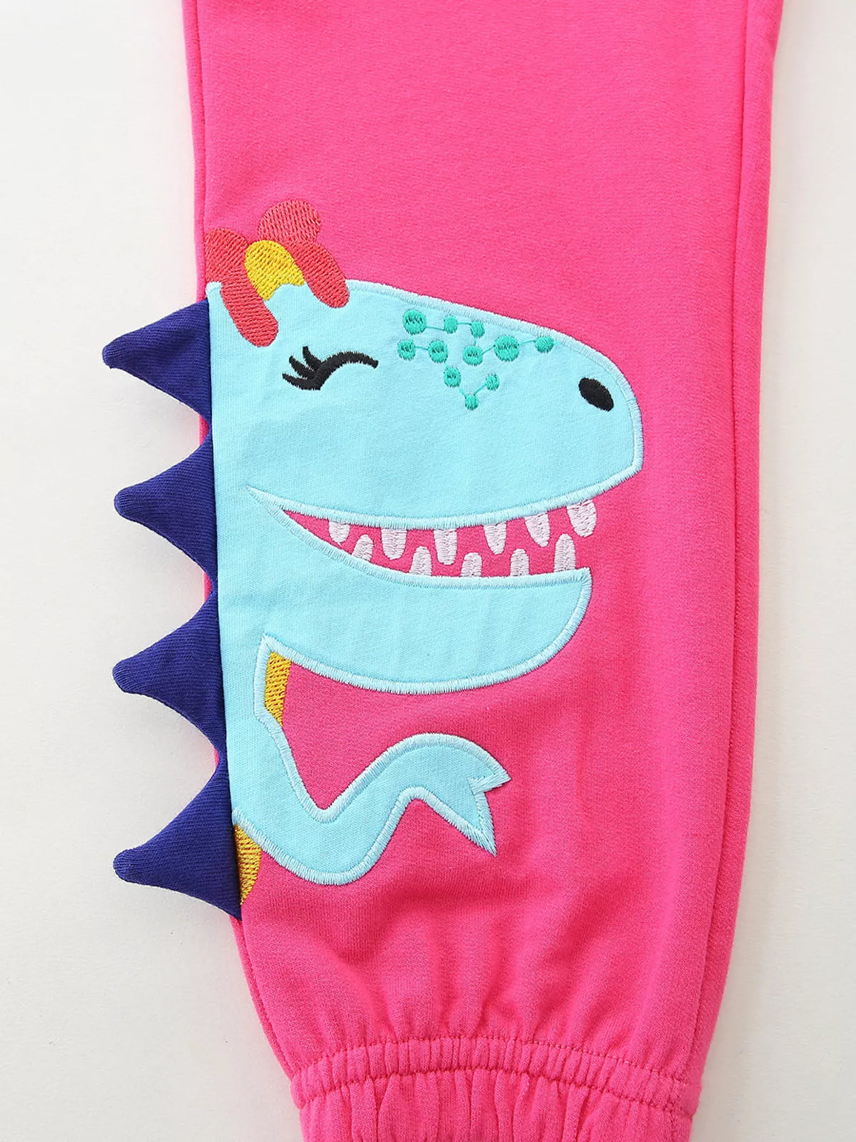 Blue dinosaur applique with purple raised spikes