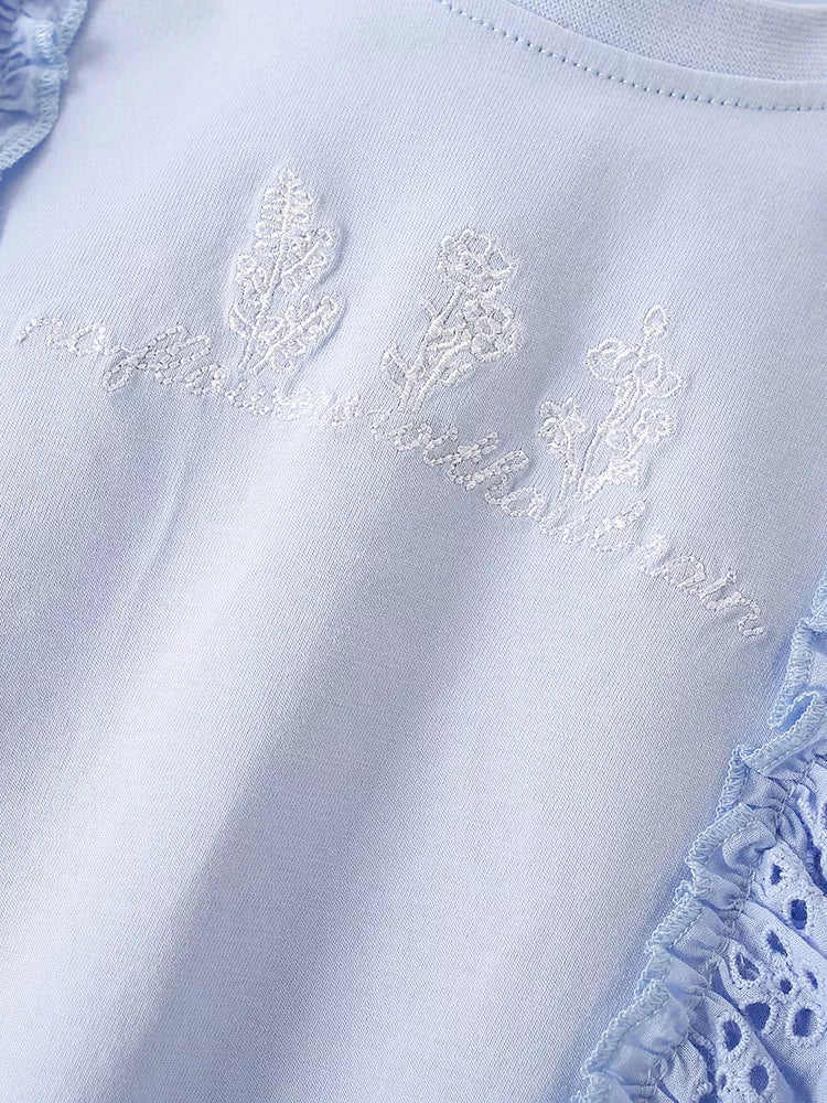 White embroidered lettering and blue eyelet ruffle