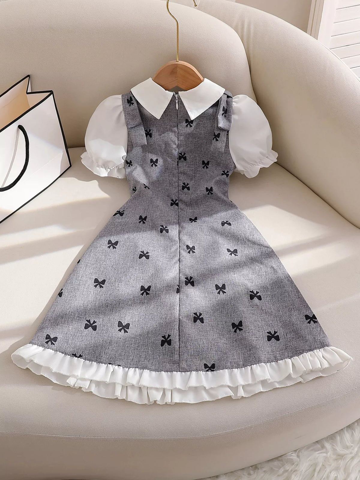 Front of the gray bow-print dress arranged on a chair