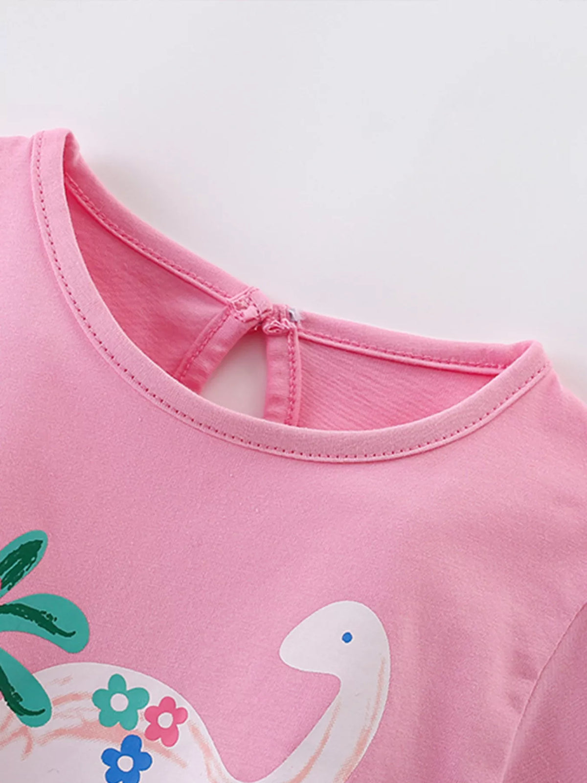 Pink floral dinosaur graphic shirt — round neckline and back keyhole