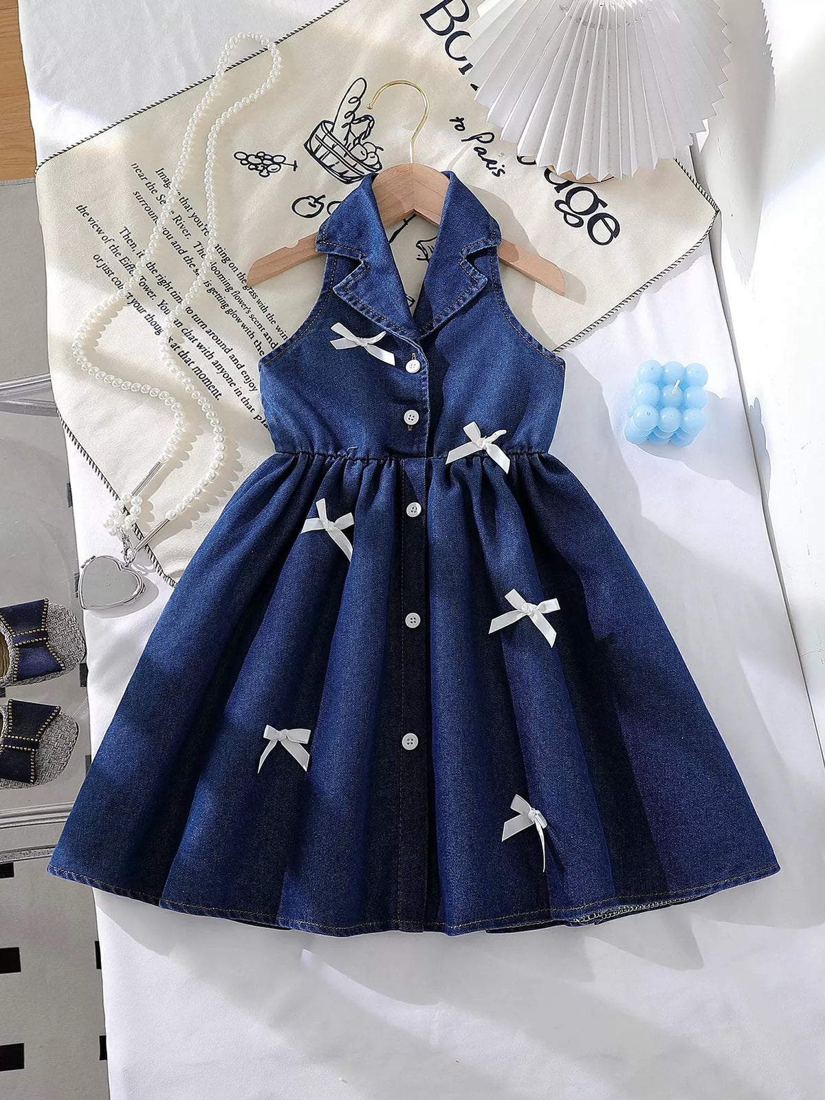 Sleeveless Denim Bow Dress — front hanging view