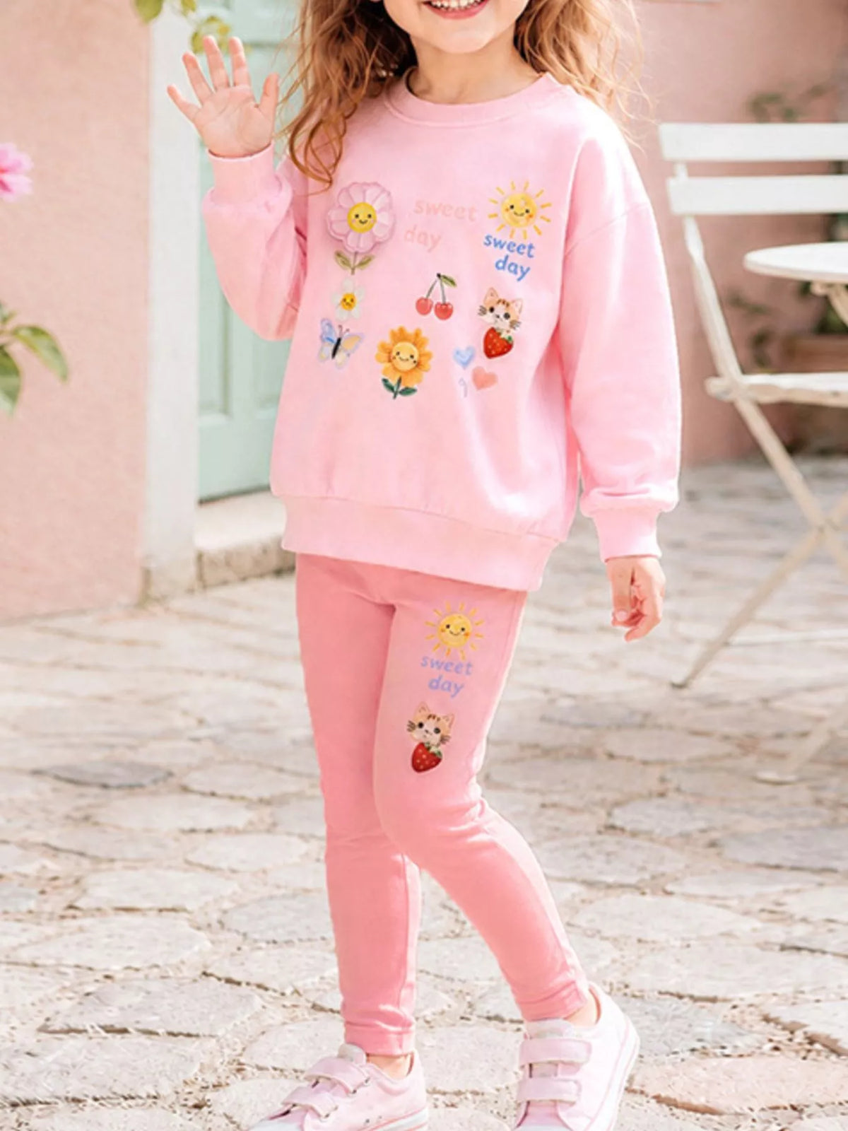 Pink Sweet Day graphic sweatshirt with pink leggings on a child