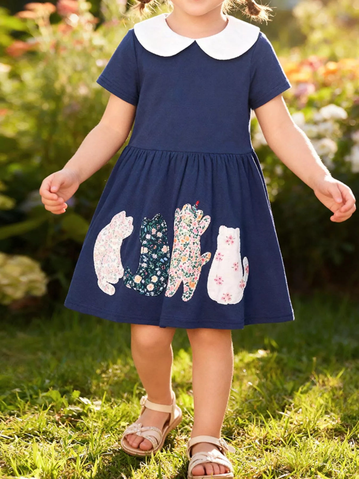 Navy cat-applique dress with a white Peter Pan collar on a child