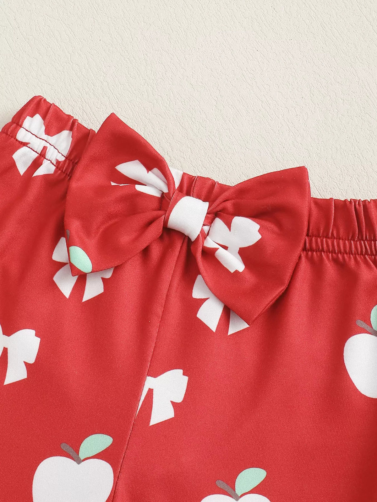 White ribbed apple bodysuit red flare pants and headband — pants waistband and bow
