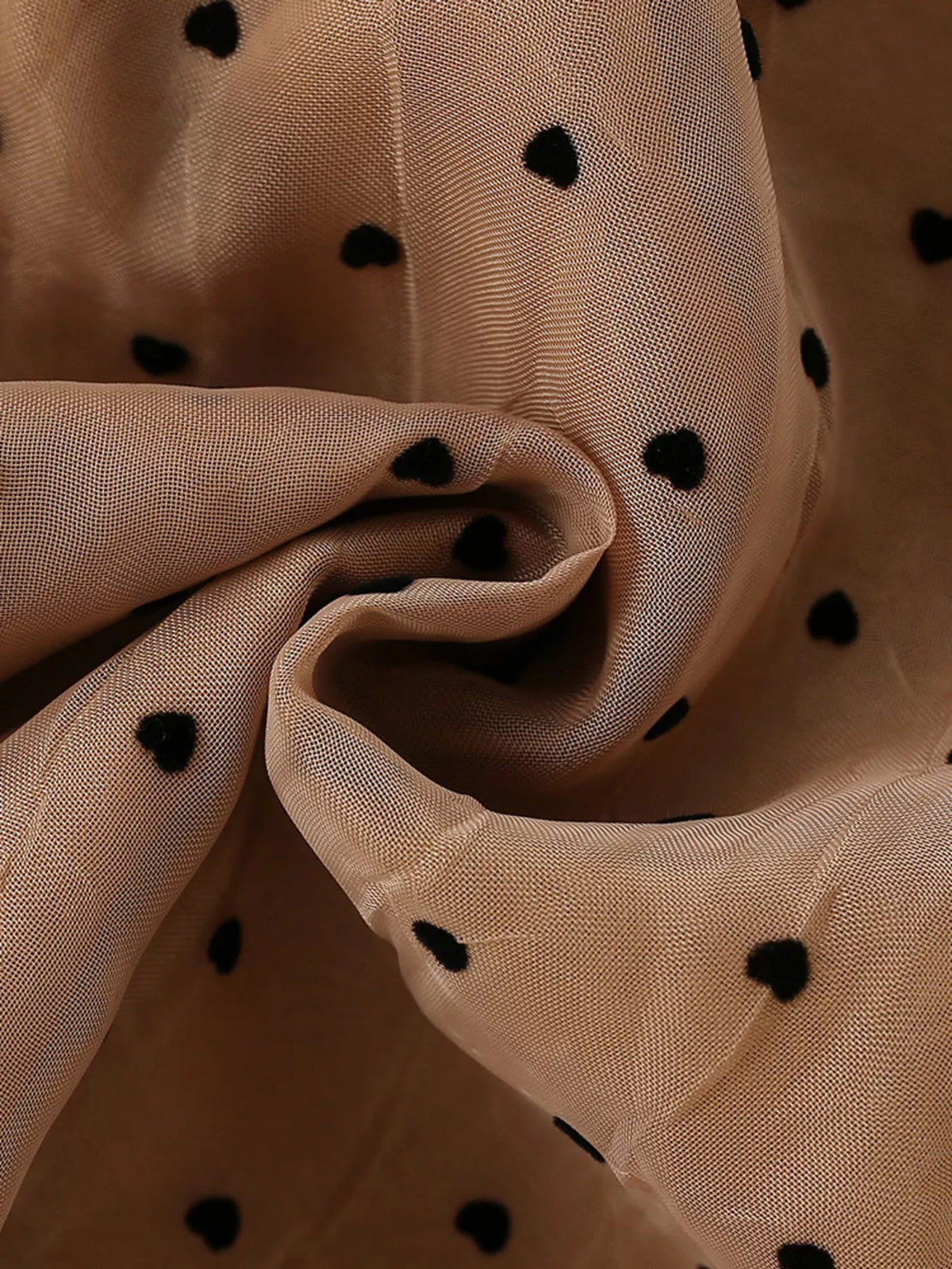 Black polka dots on sheer caramel fabric