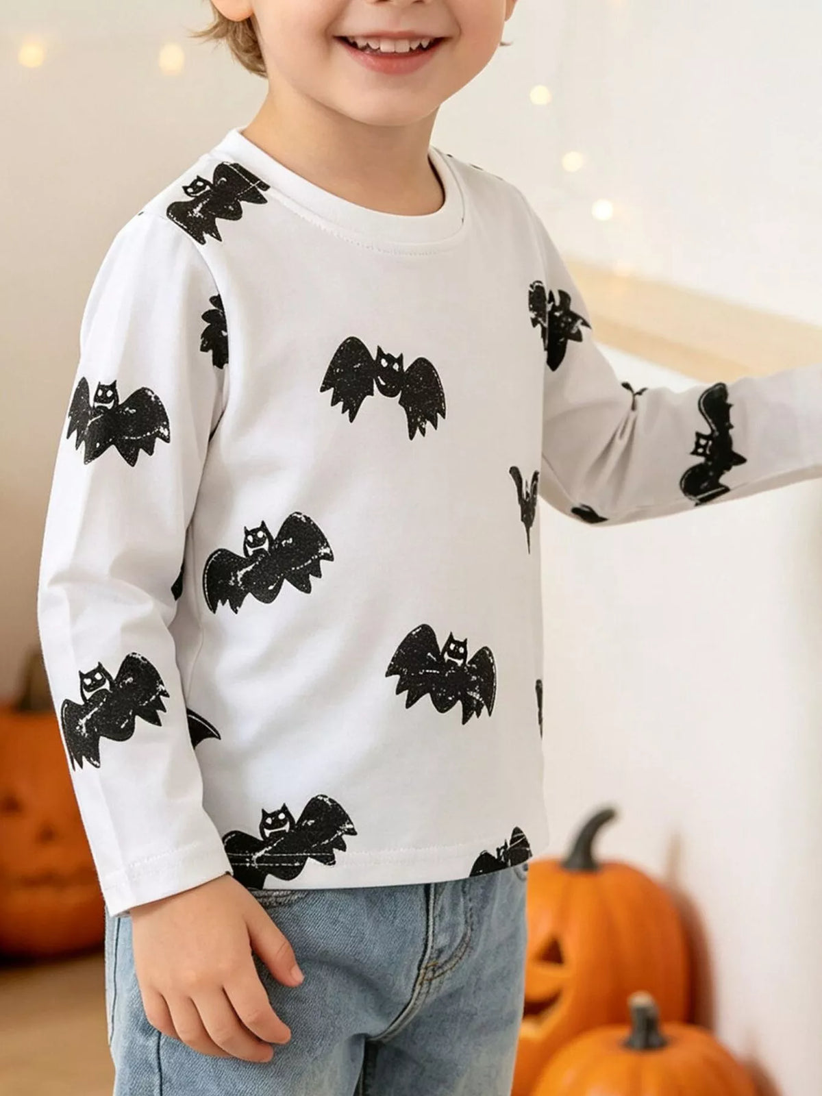 White long-sleeve tee with black bat print on a child