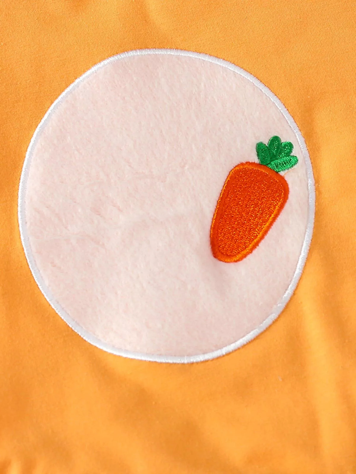 Carrot applique on a pale oval belly panel