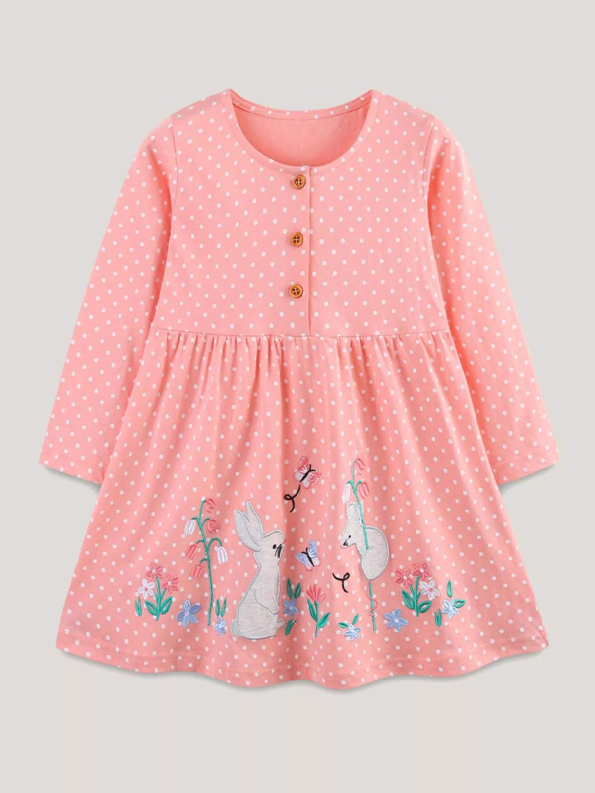 Pink polka-dot long-sleeve dress with bunny motifs laid flat