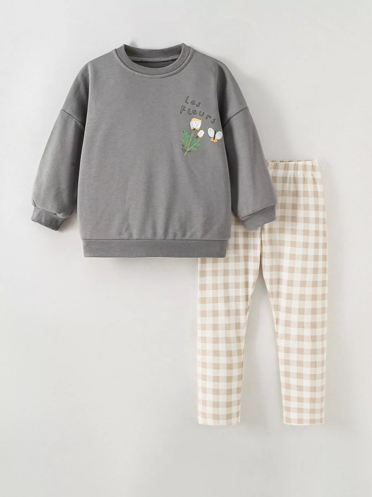 Gray floral sweatshirt with beige checked pants laid flat