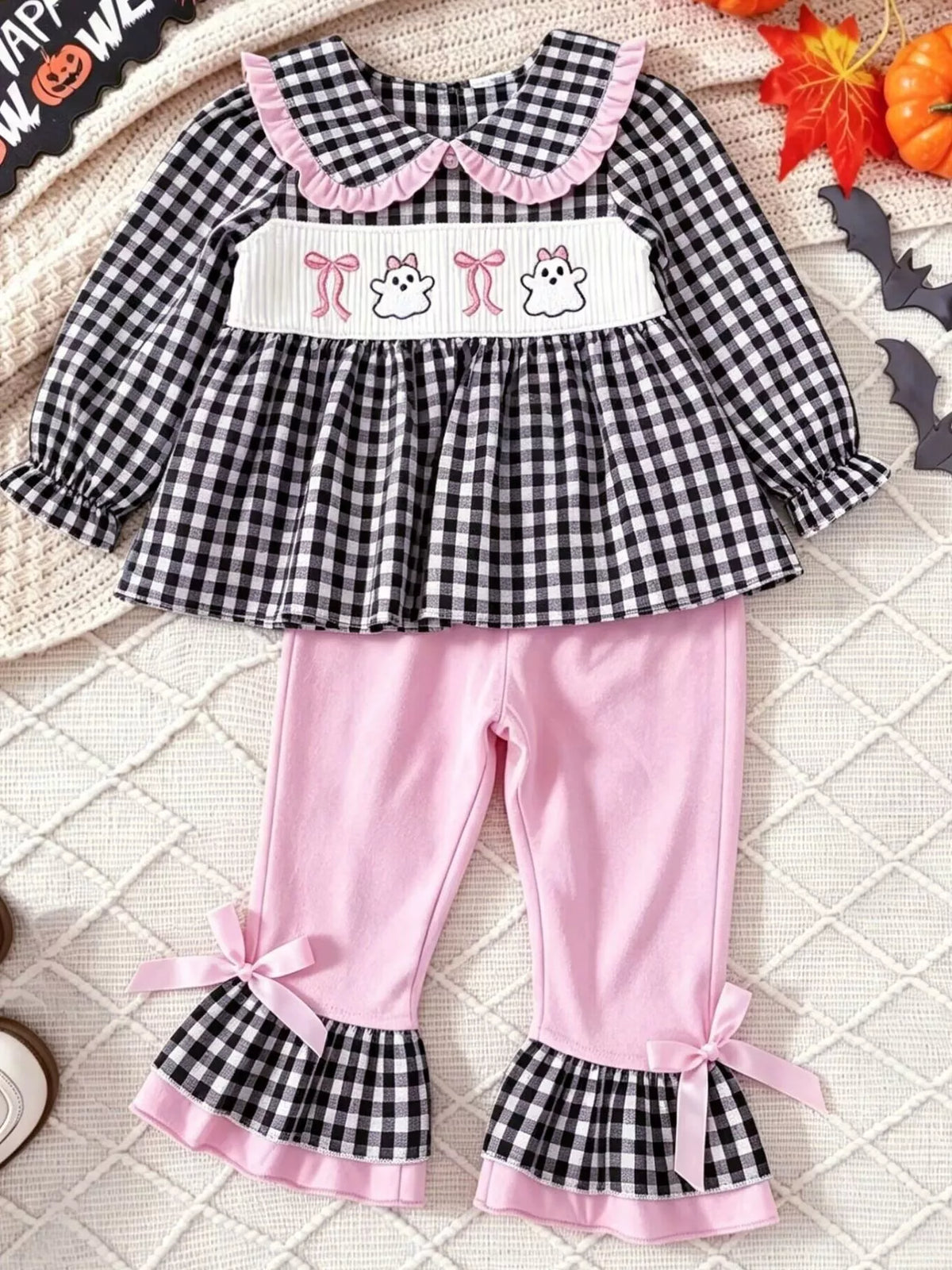 Black gingham ghost top with pink ruffle-hem pants laid flat
