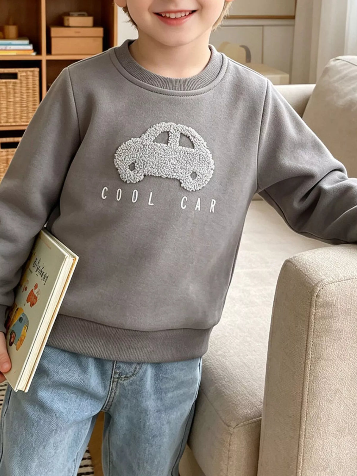 Gray crewneck sweatshirt with a textured car applique on a child