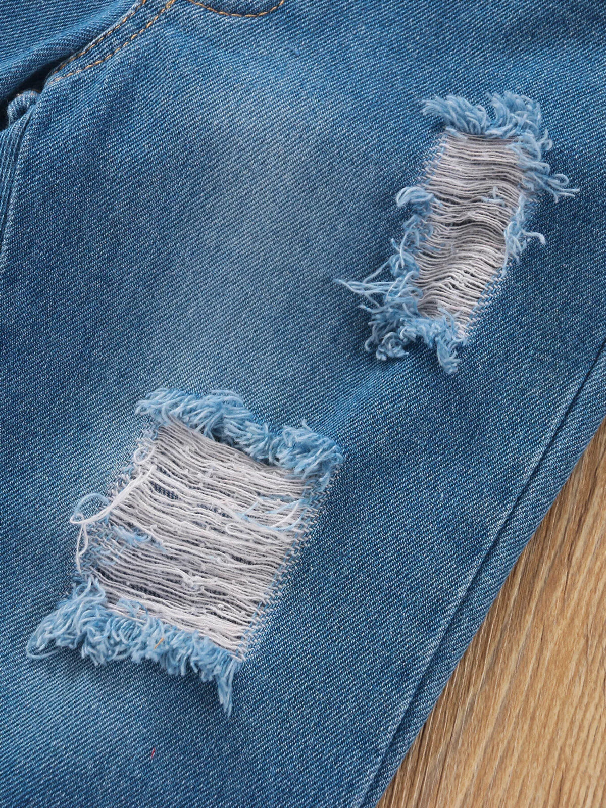 Frayed distressed patches on blue denim