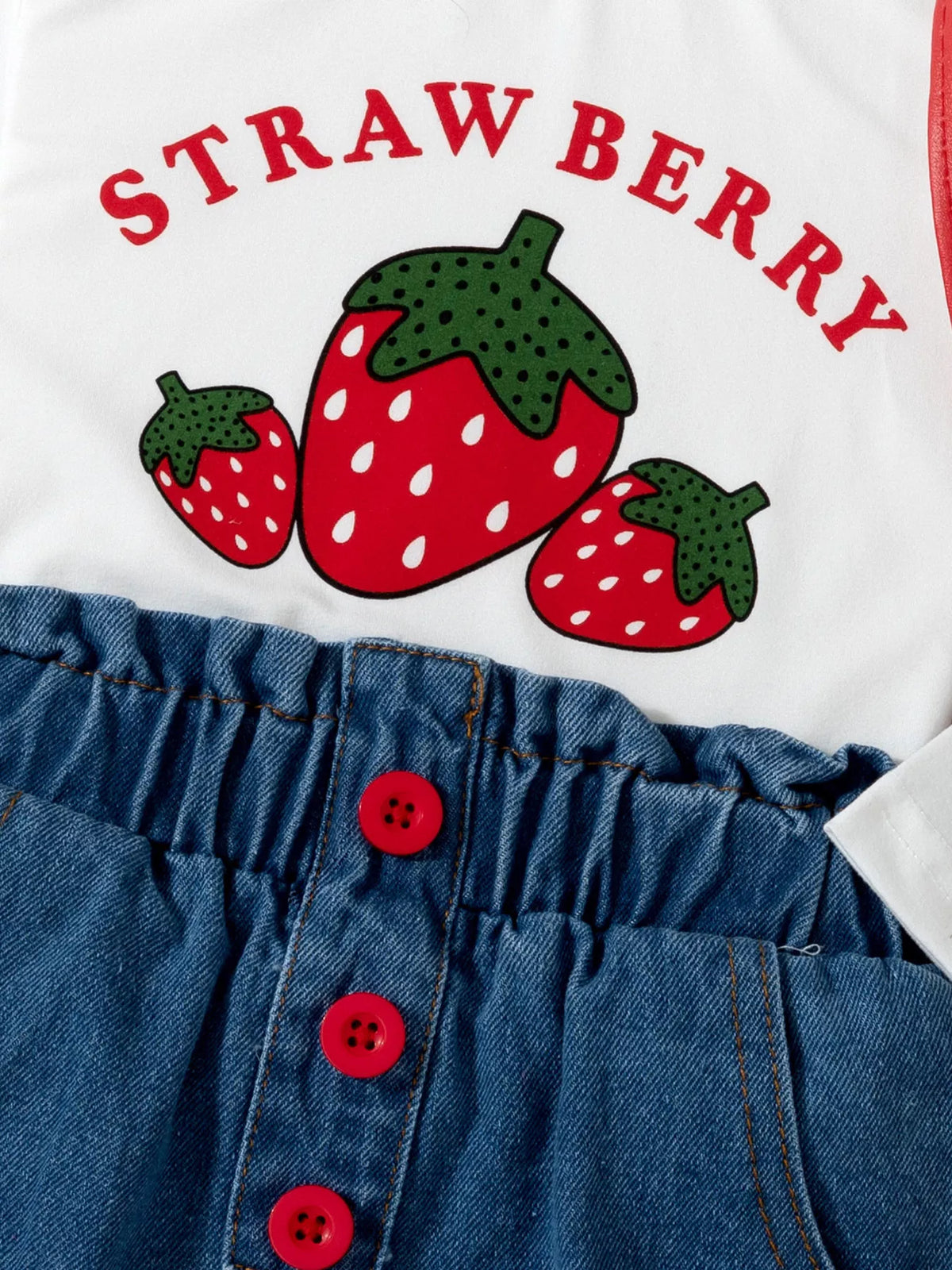 Strawberry graphic above red jeans buttons